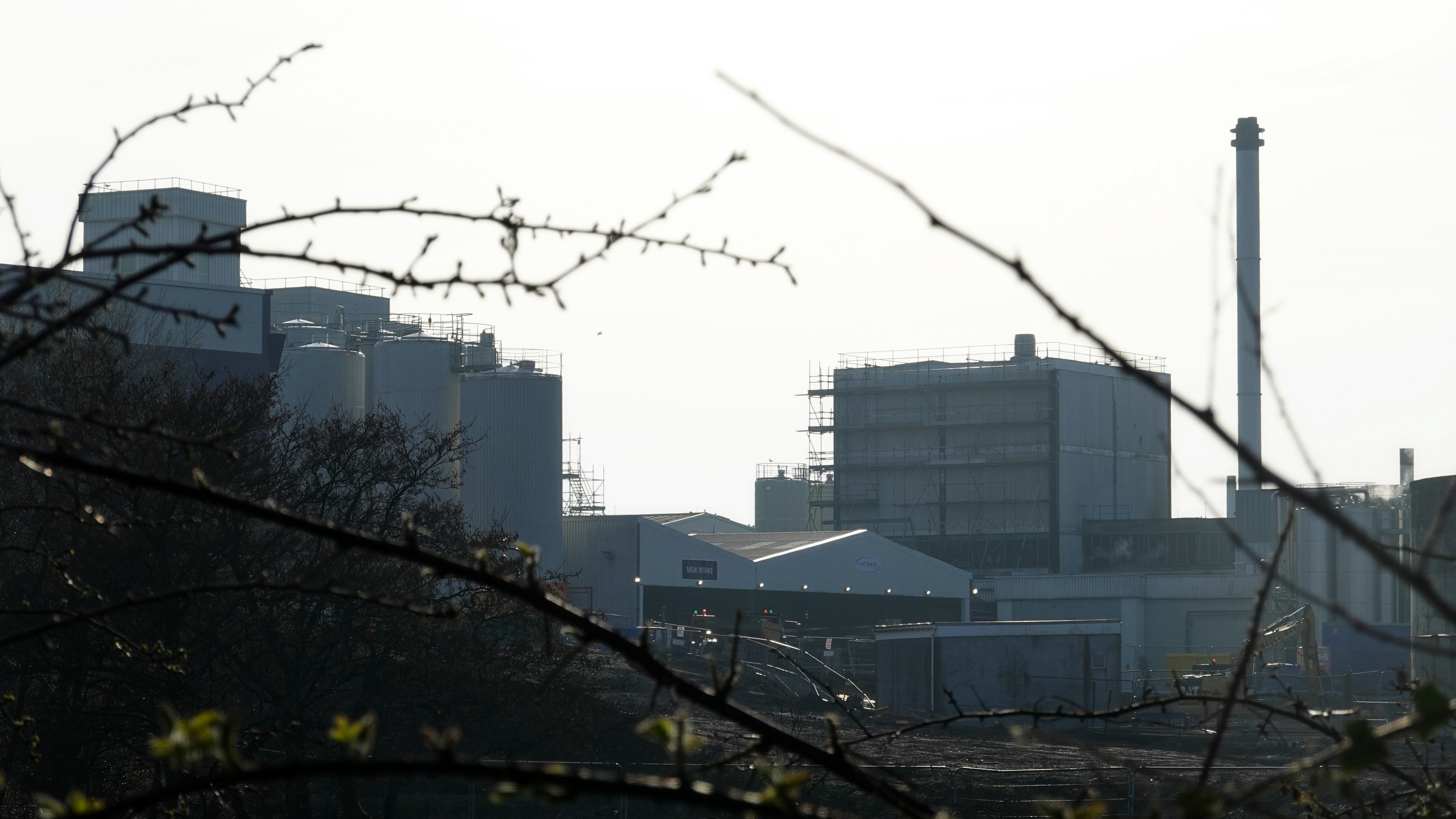 Complejo industrial con chimenea contra cielo brumoso