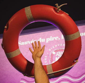 A hand reaches for a red life preserver