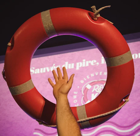A hand reaches for a red life preserver