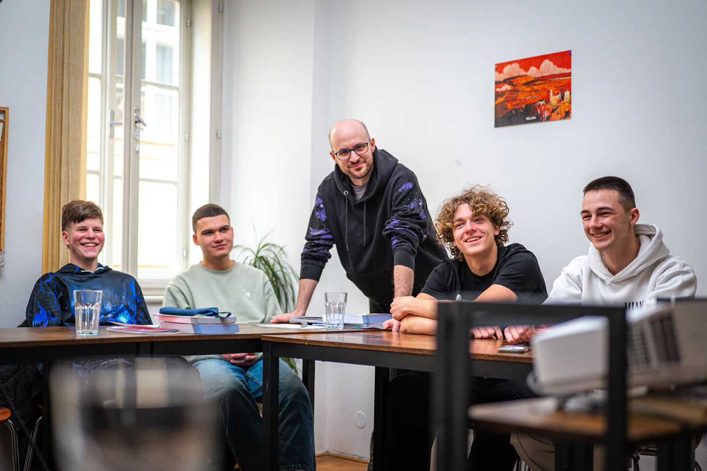 A mentor working with a group of young men around a table