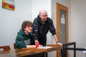Two men looking at something on a table