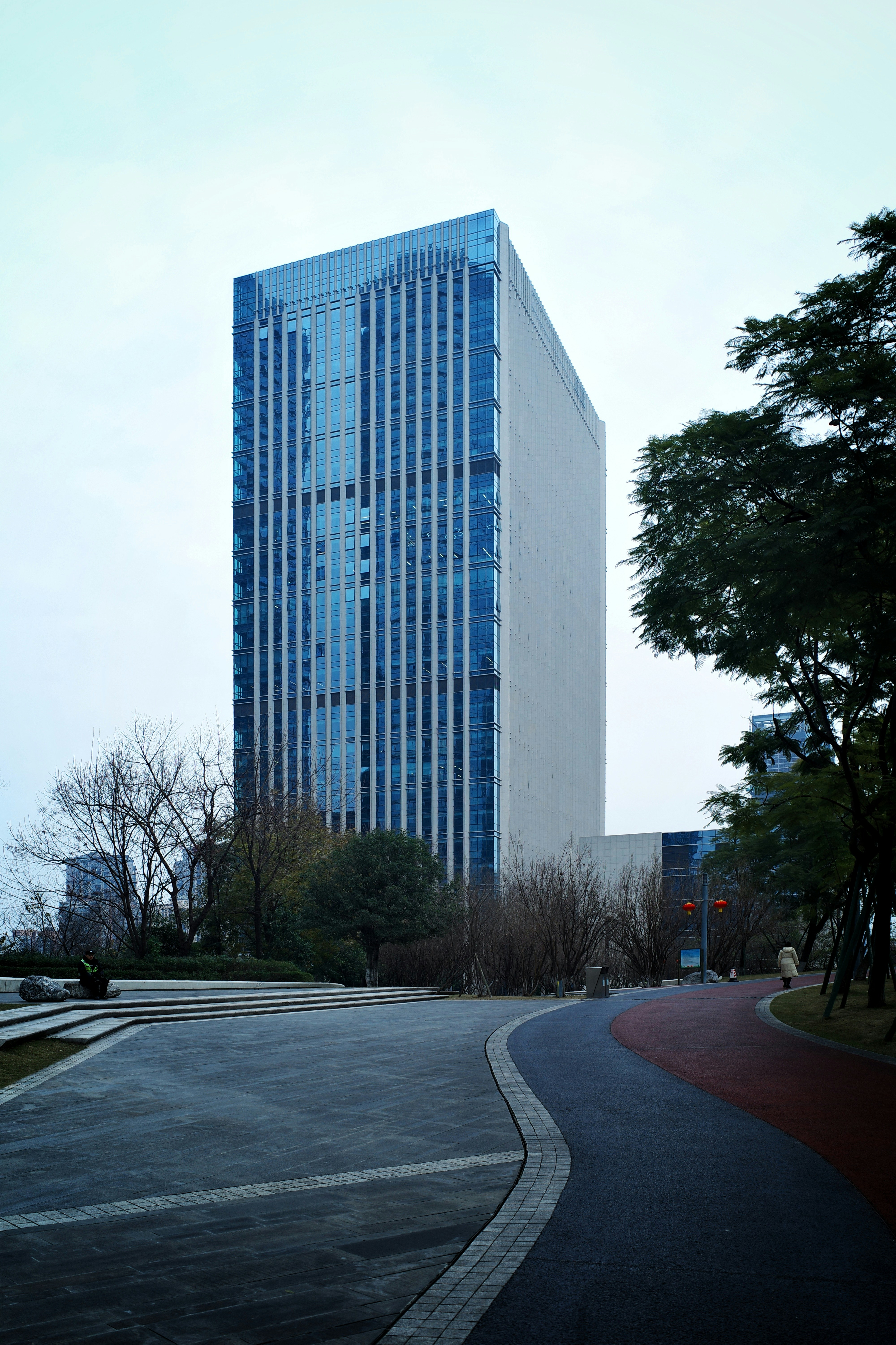 Modern glass skyscraper against an overcast sky.