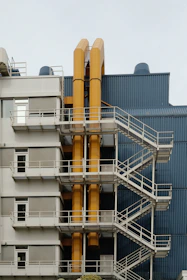 Modern building exterior with yellow pipes and stairs