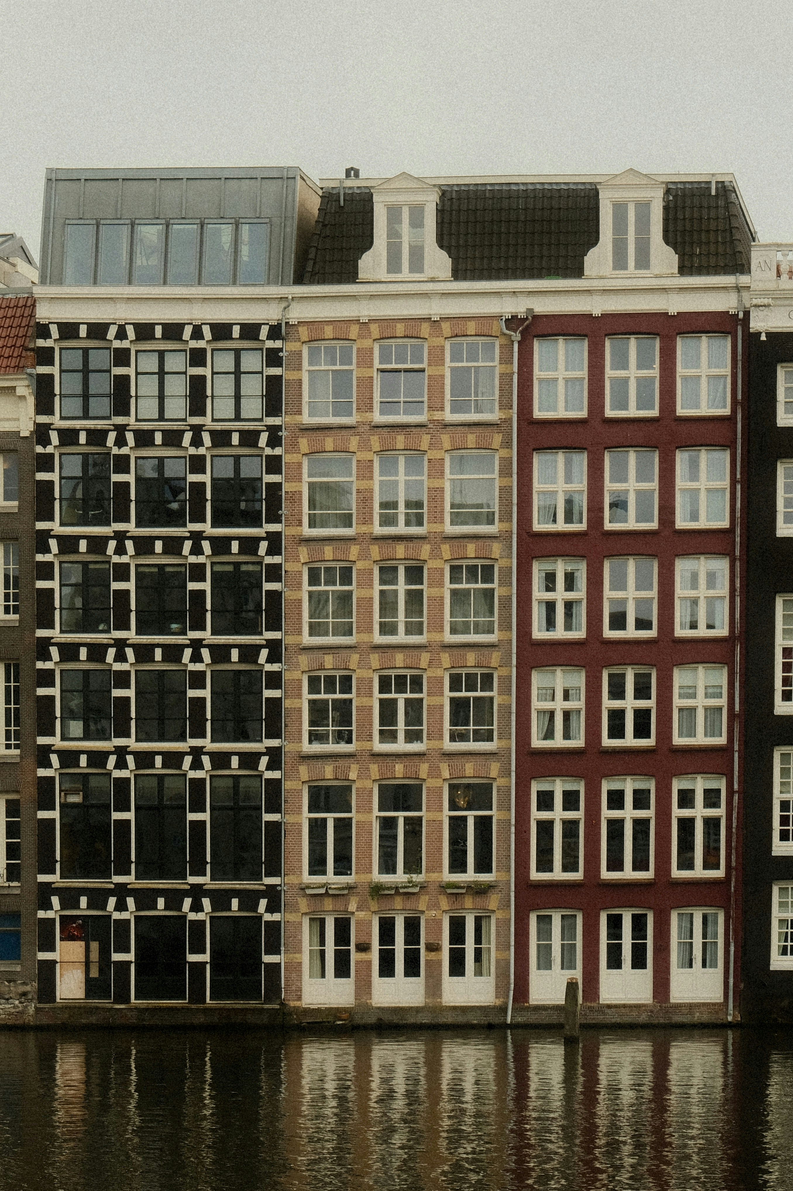 Colorful buildings line a canal in amsterdam.