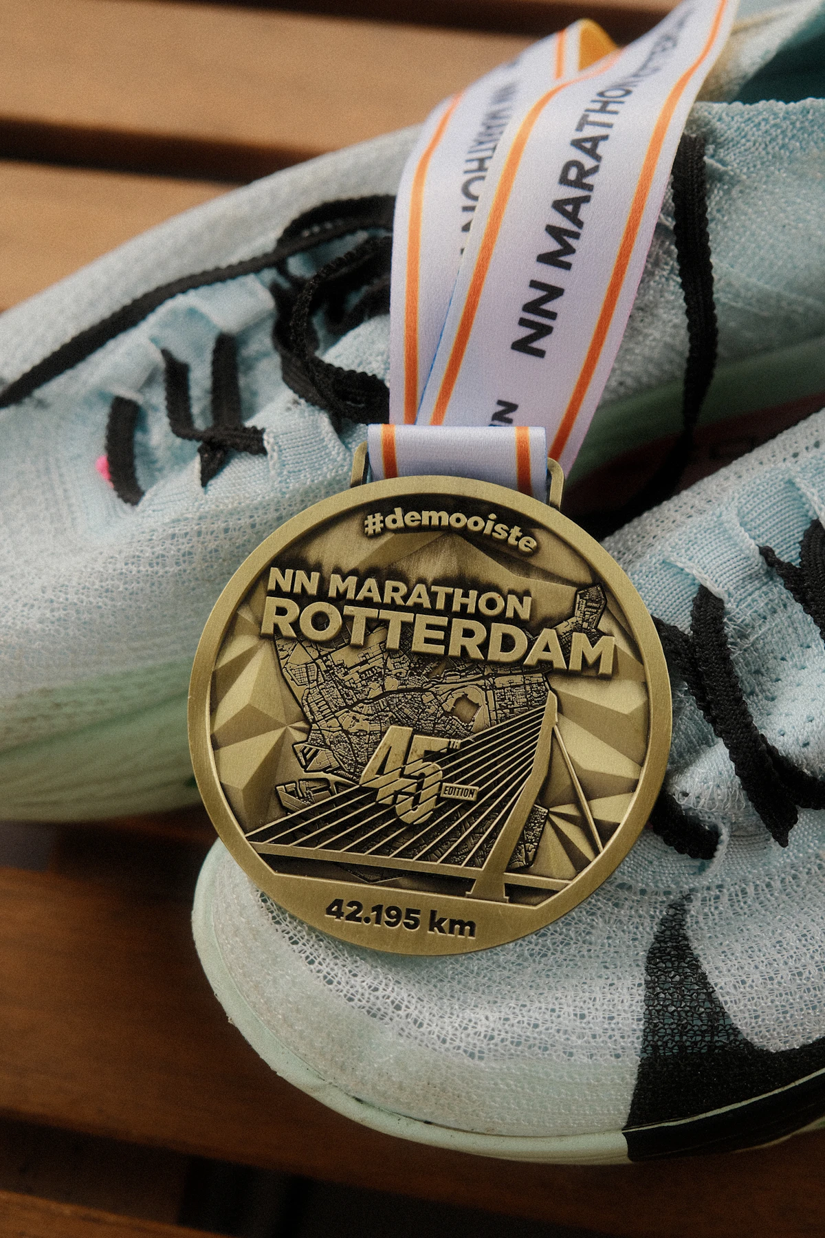 Race medal and running shoes on a wooden bench