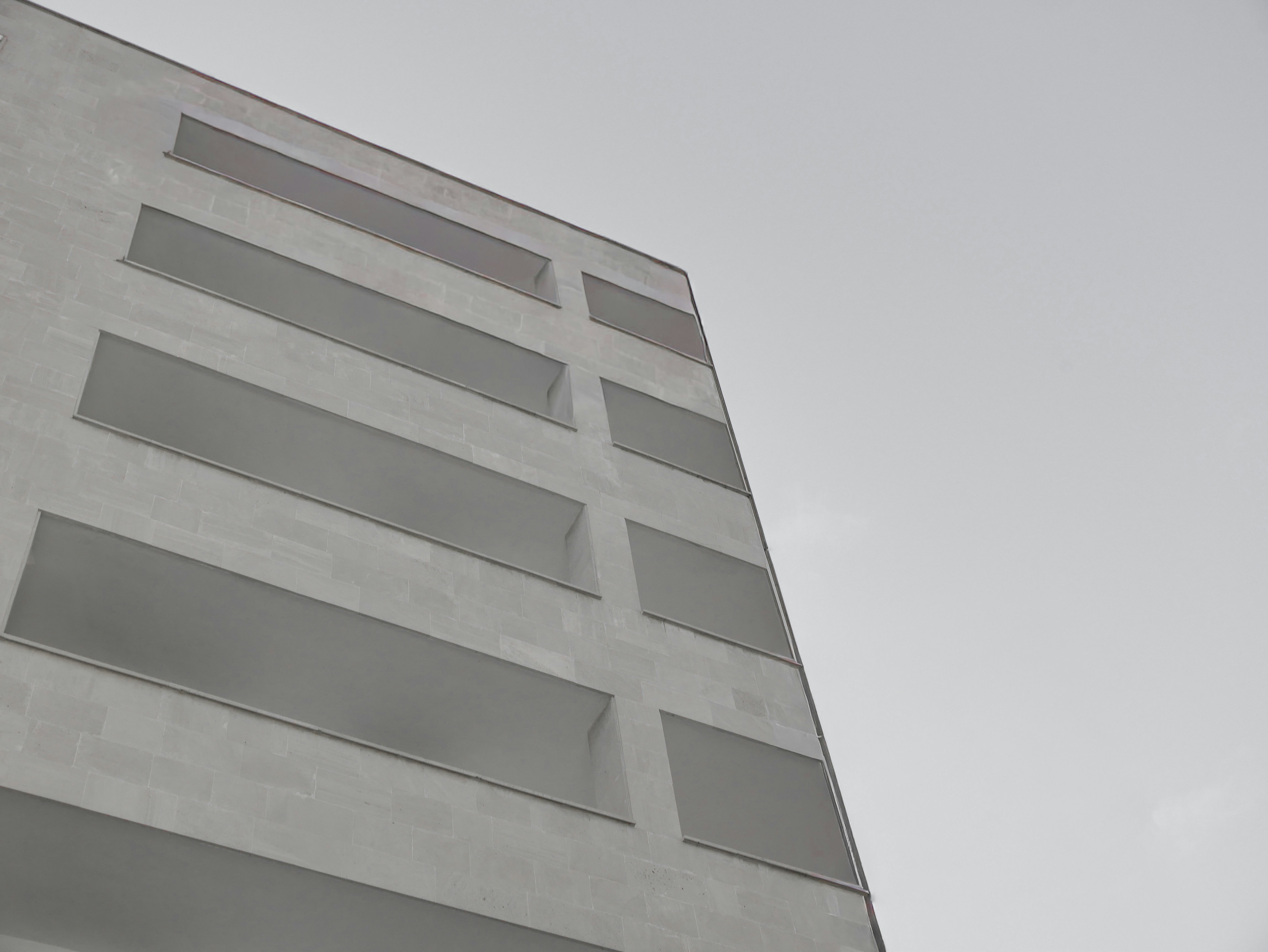 Fachada moderna del edificio con balcones geométricos frente al cielo