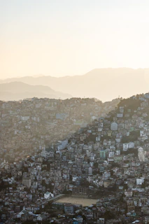 Dense city buildings on a steep hillside at sunset