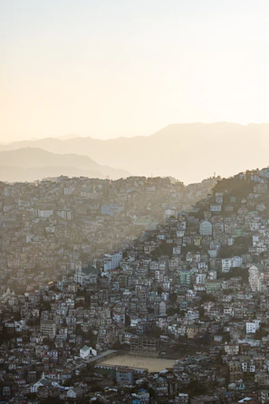 Dense city buildings on a steep hillside at sunset
