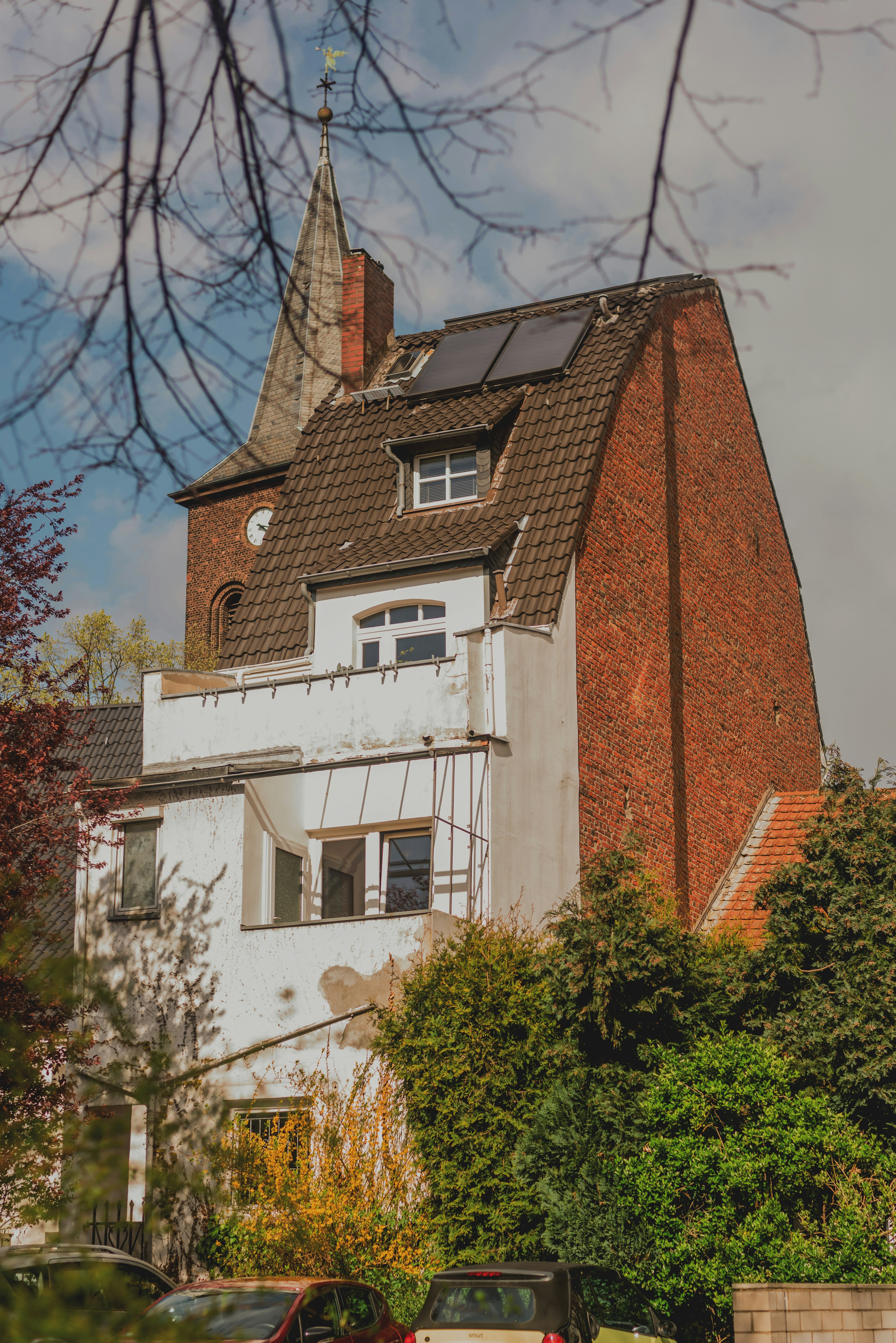 Building with solar panels and church steeple in background.