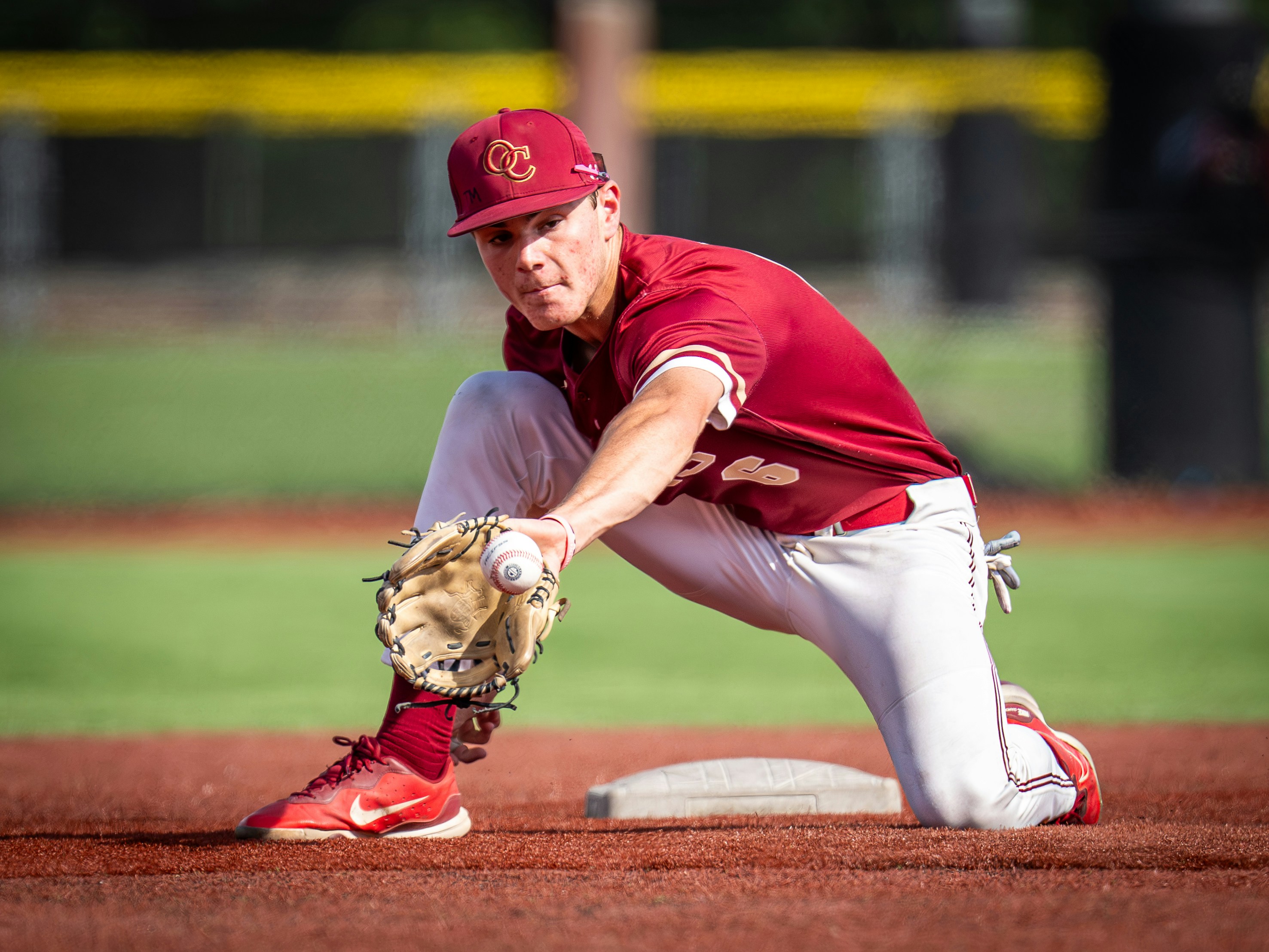 Baseball player in uniform fielding a ball