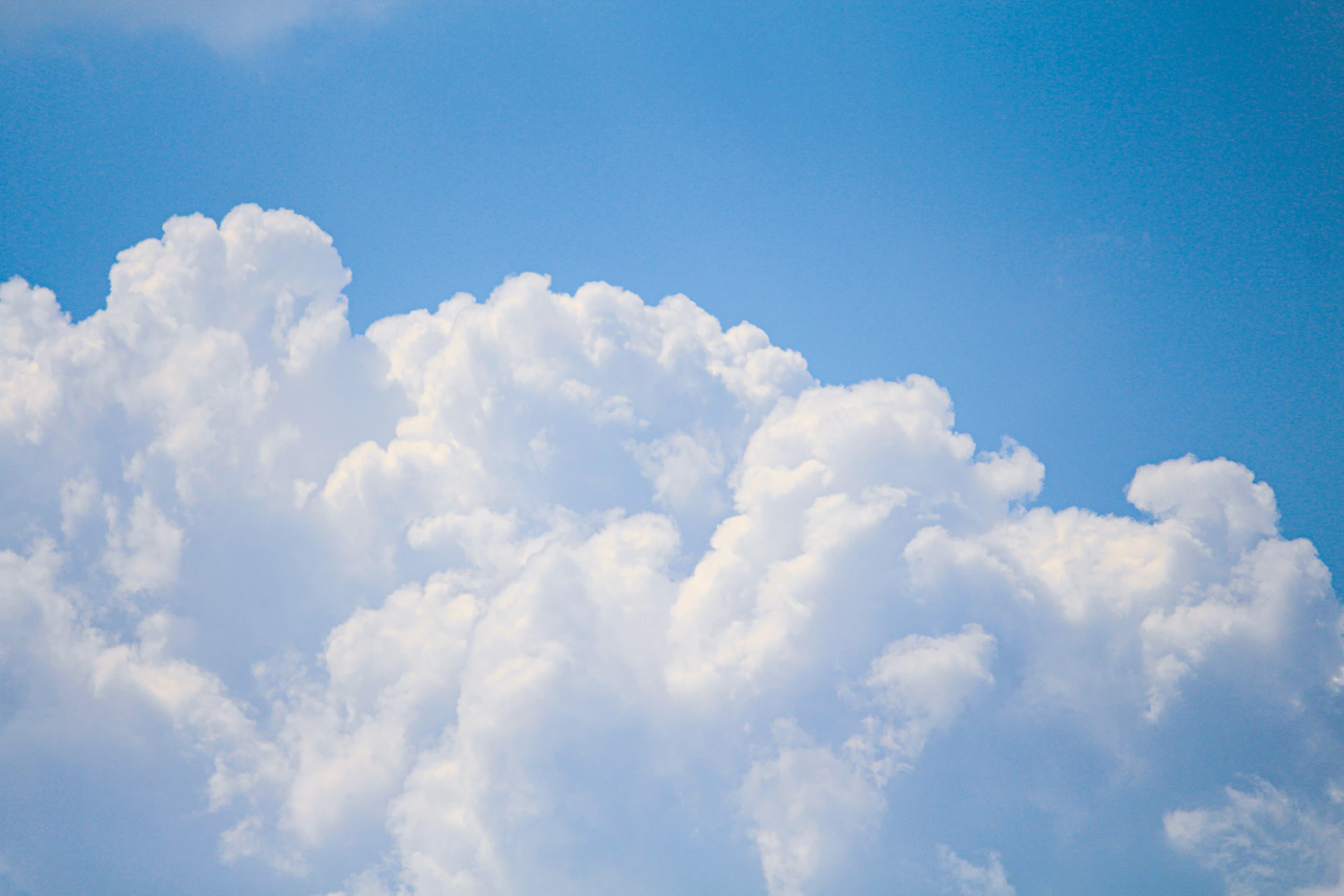 Fluffy white clouds against a clear blue sky.