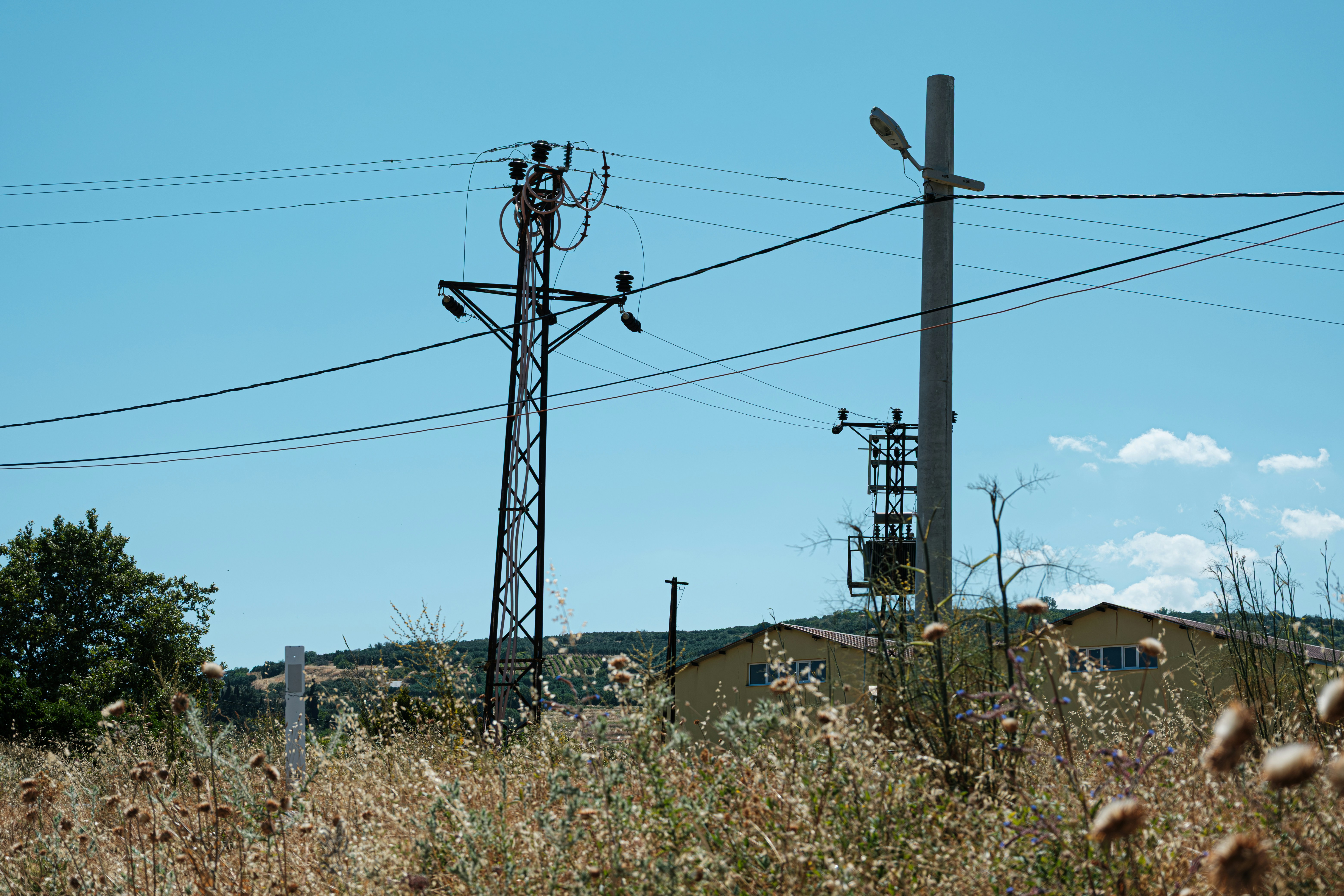 Stromleitungen und Masten vor einem klaren blauen Himmel.