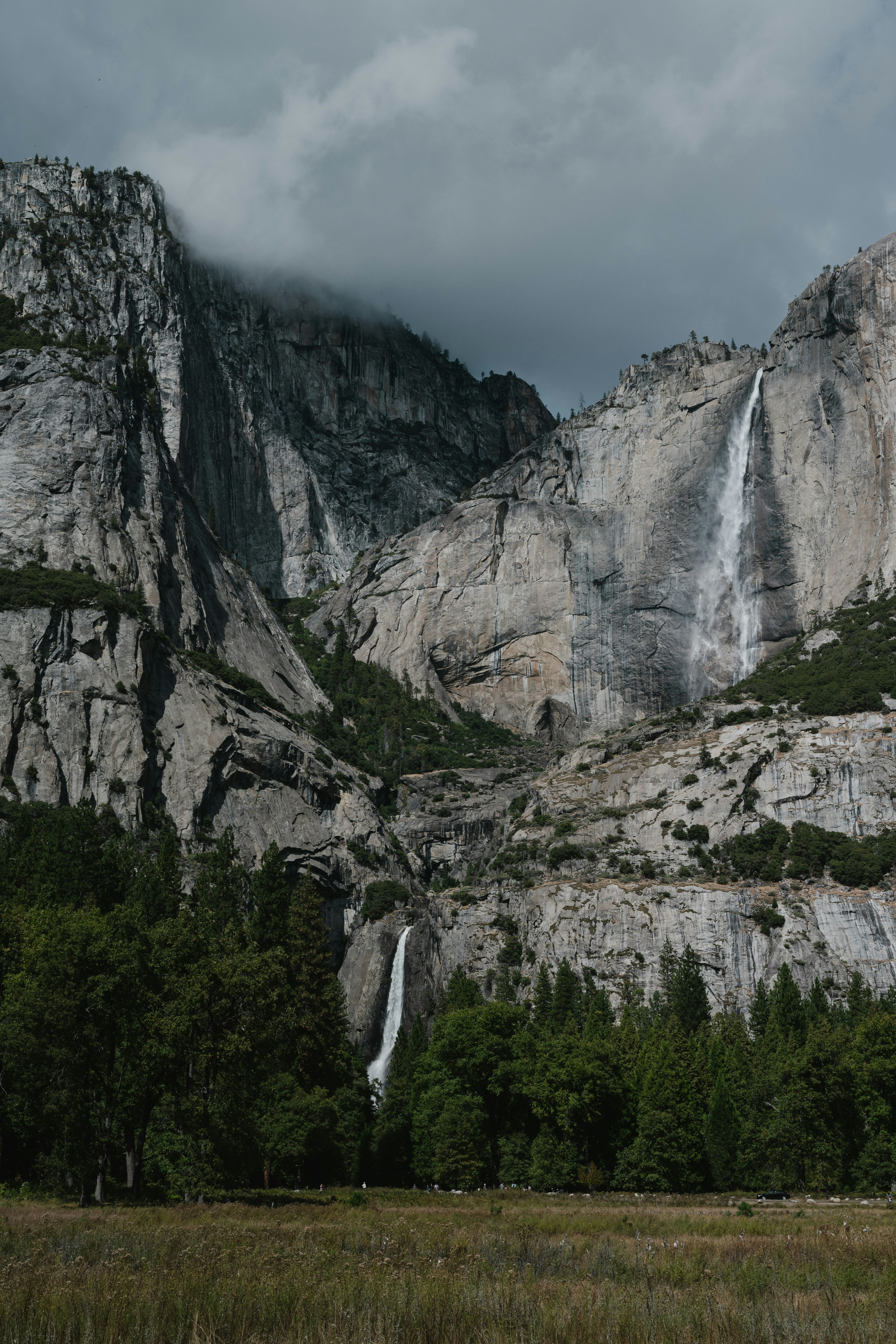 Two waterfalls cascade down a rocky mountain face.