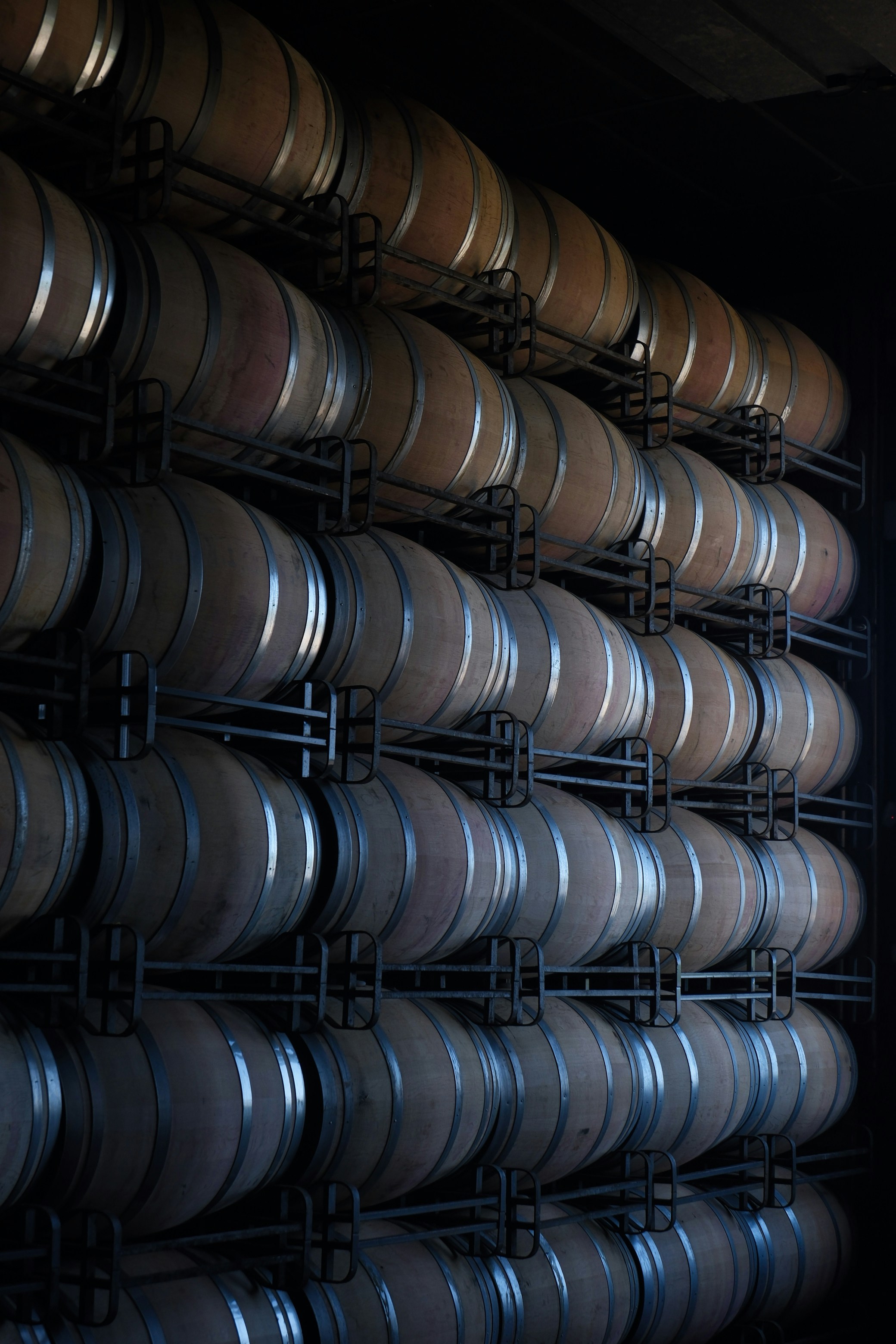 Barriles de vino apilados en una bodega oscura
