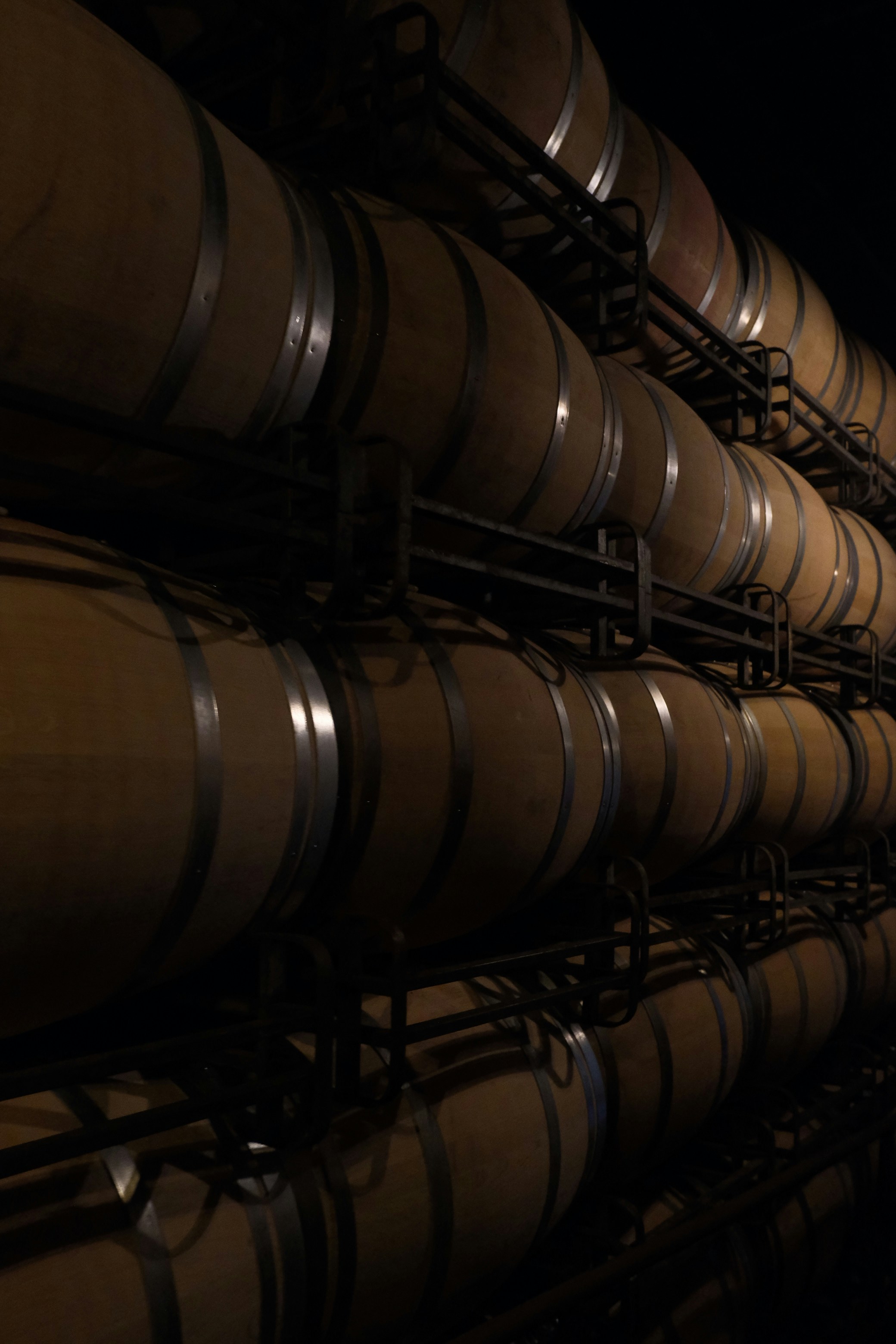 Barriles de vino apilados en una bodega oscura
