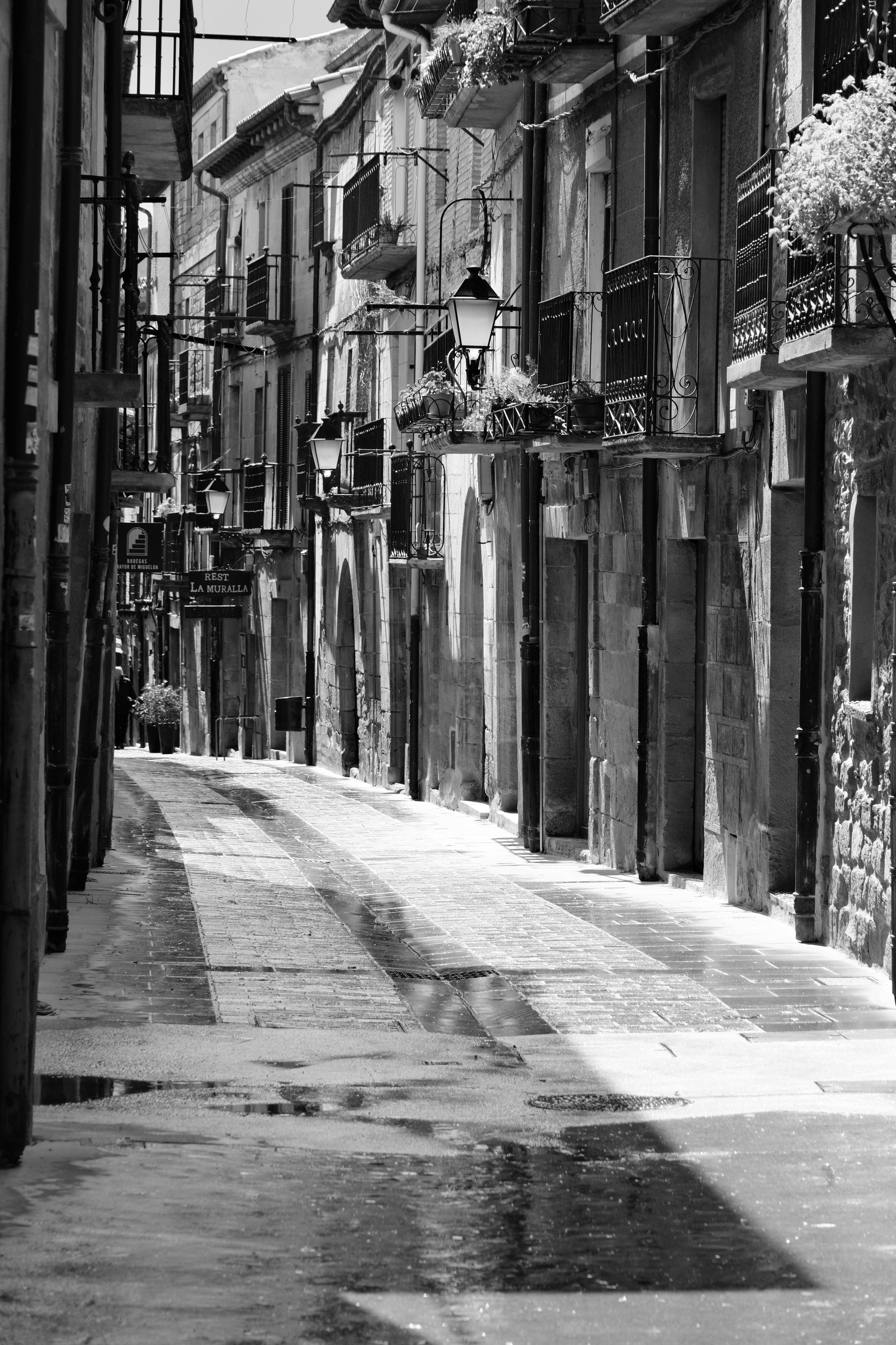 Una calle estrecha de adoquines con edificios y balcones.
