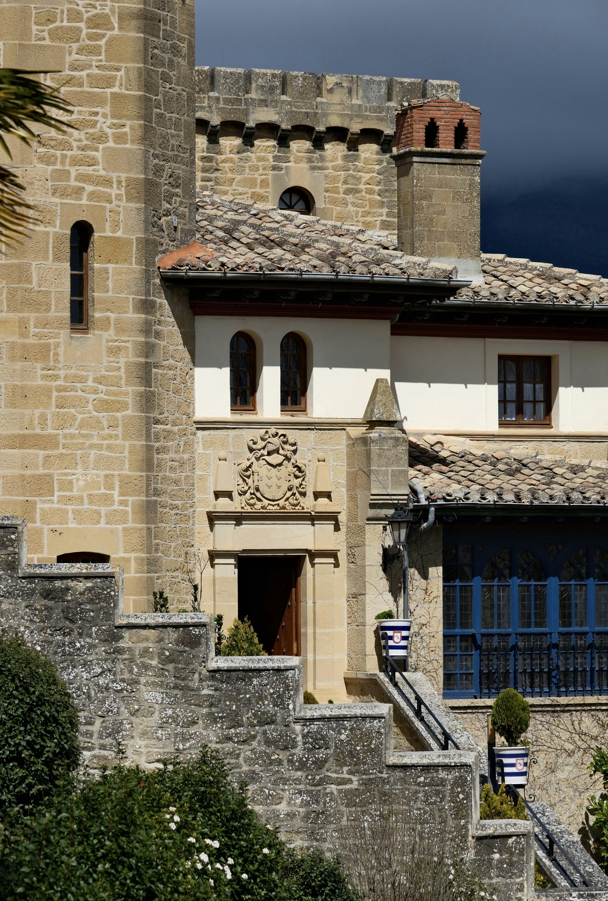 Castillo de piedra con tejados de teja y ventanas azules