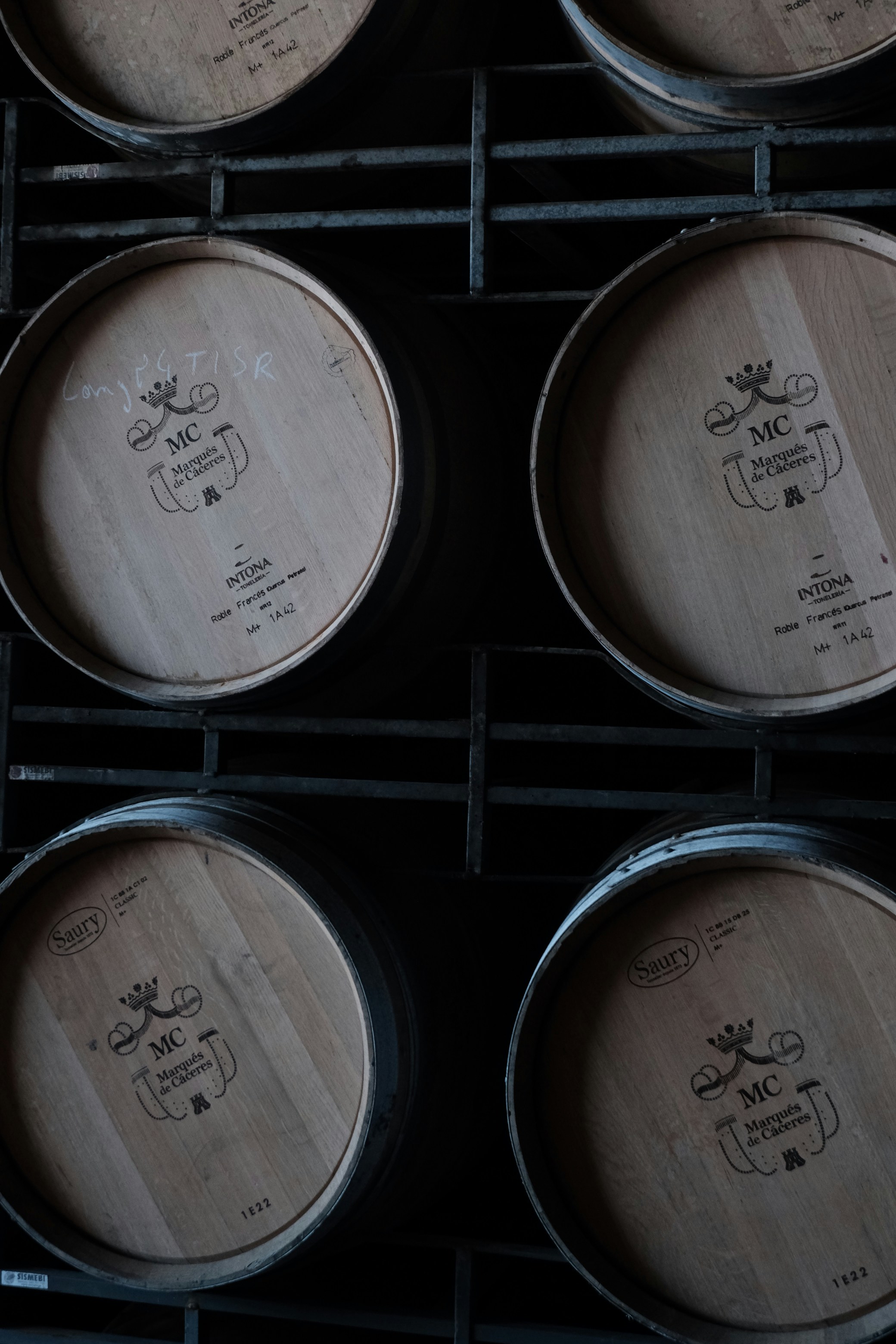 Barriles de madera apilados en un sótano oscuro.