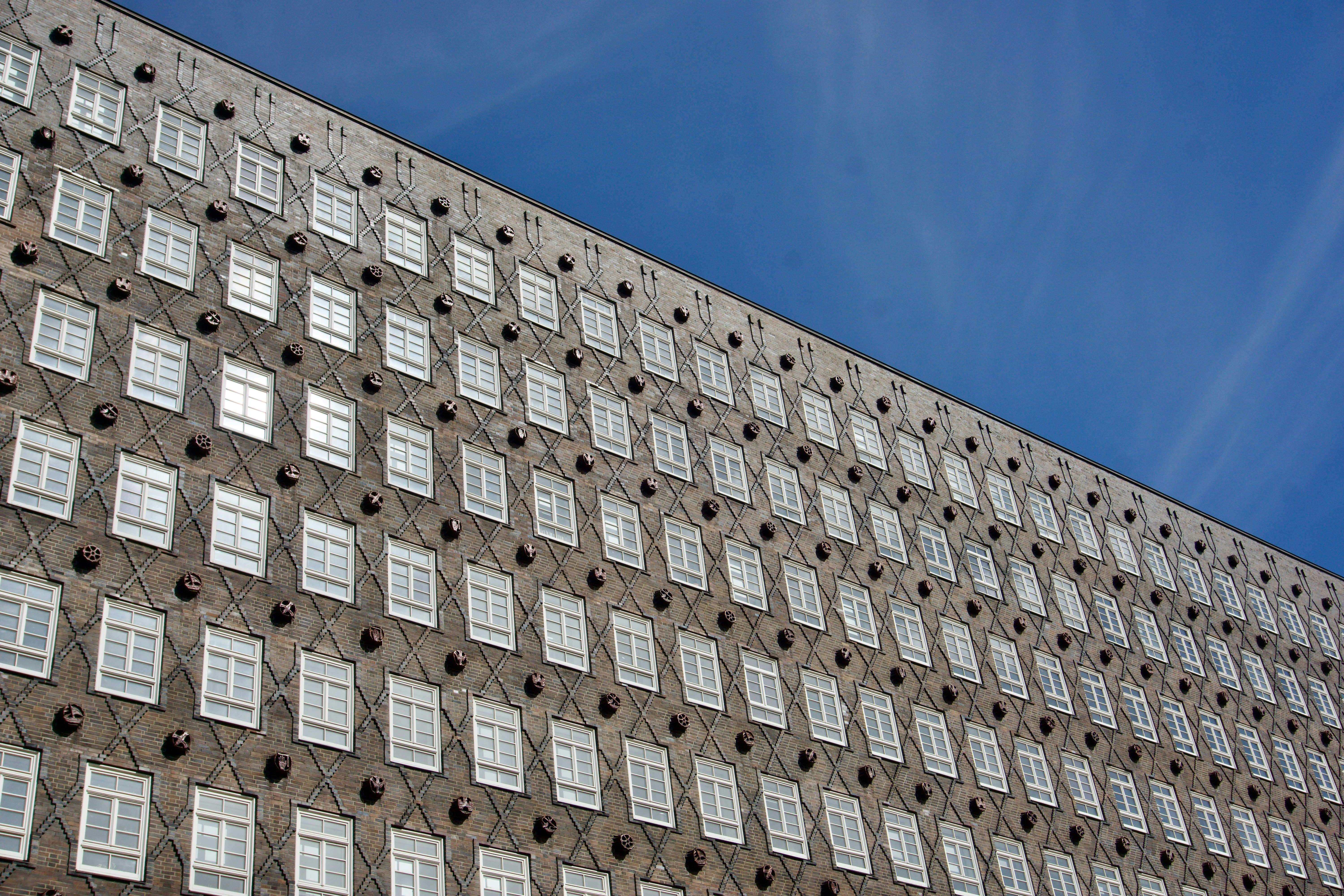 Modern building facade with many windows against blue sky