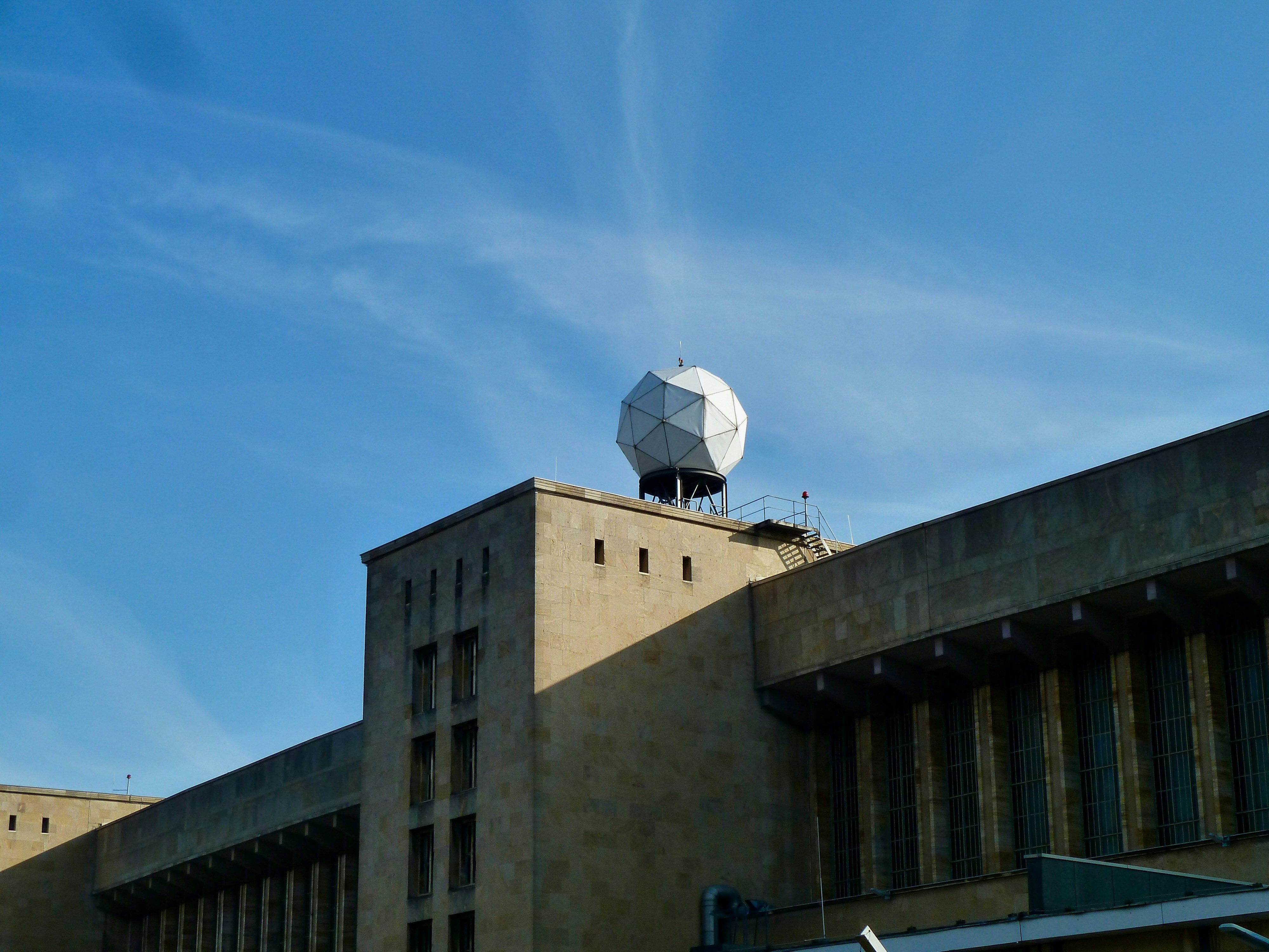 A white geodesic dome sits atop a concrete building.