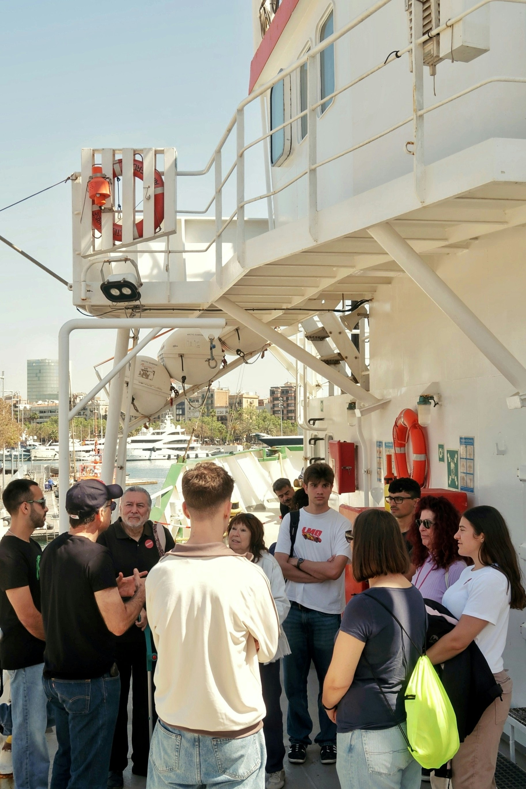 A group of families and guests gathered on the deck of a dolphin watching boat