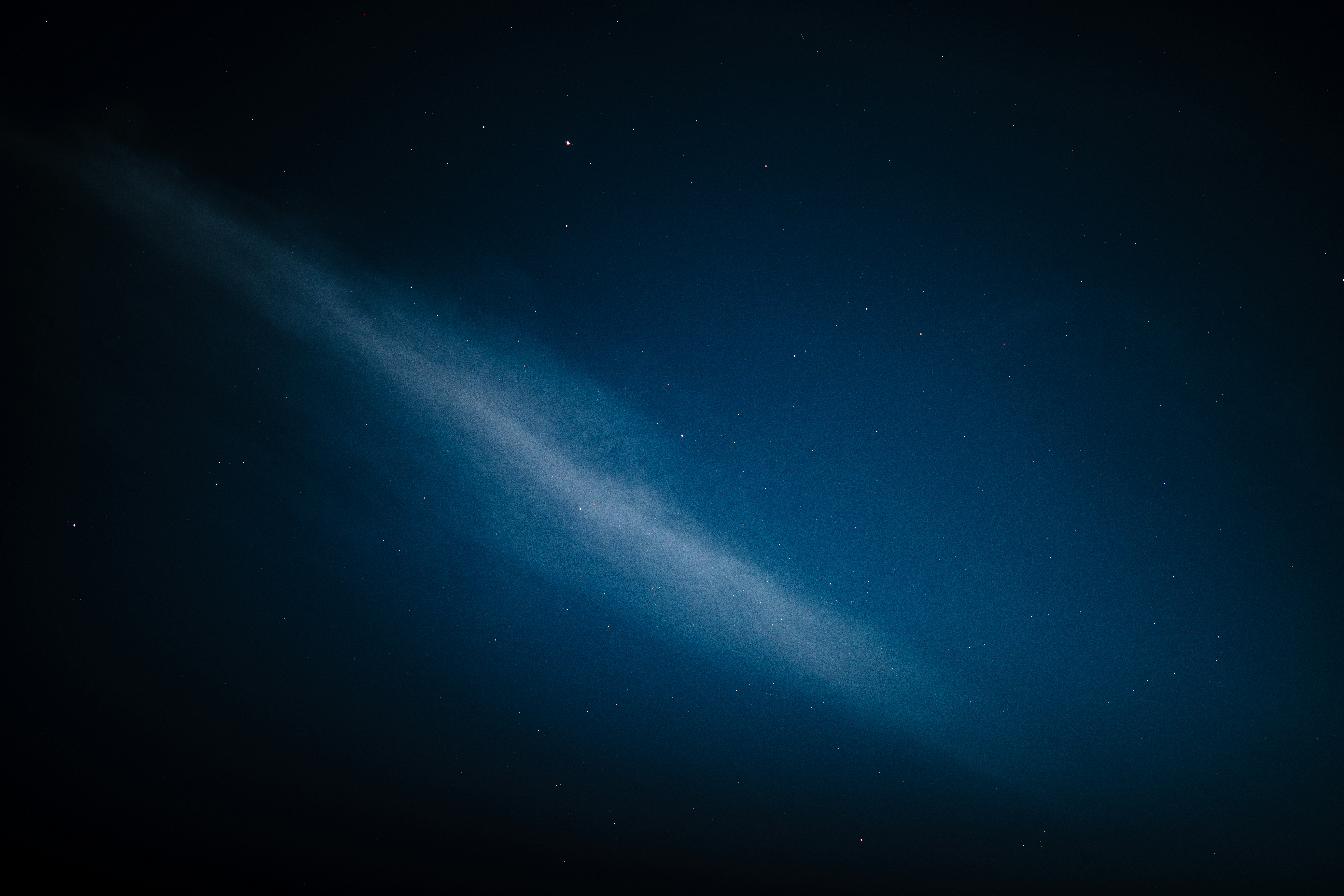 A wispy cloud formation in a starry night sky