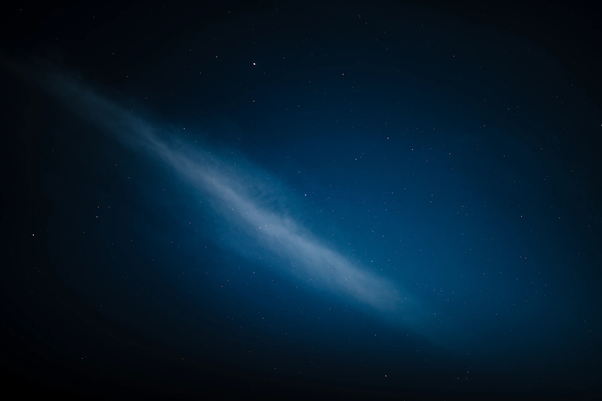 A wispy cloud formation in a starry night sky