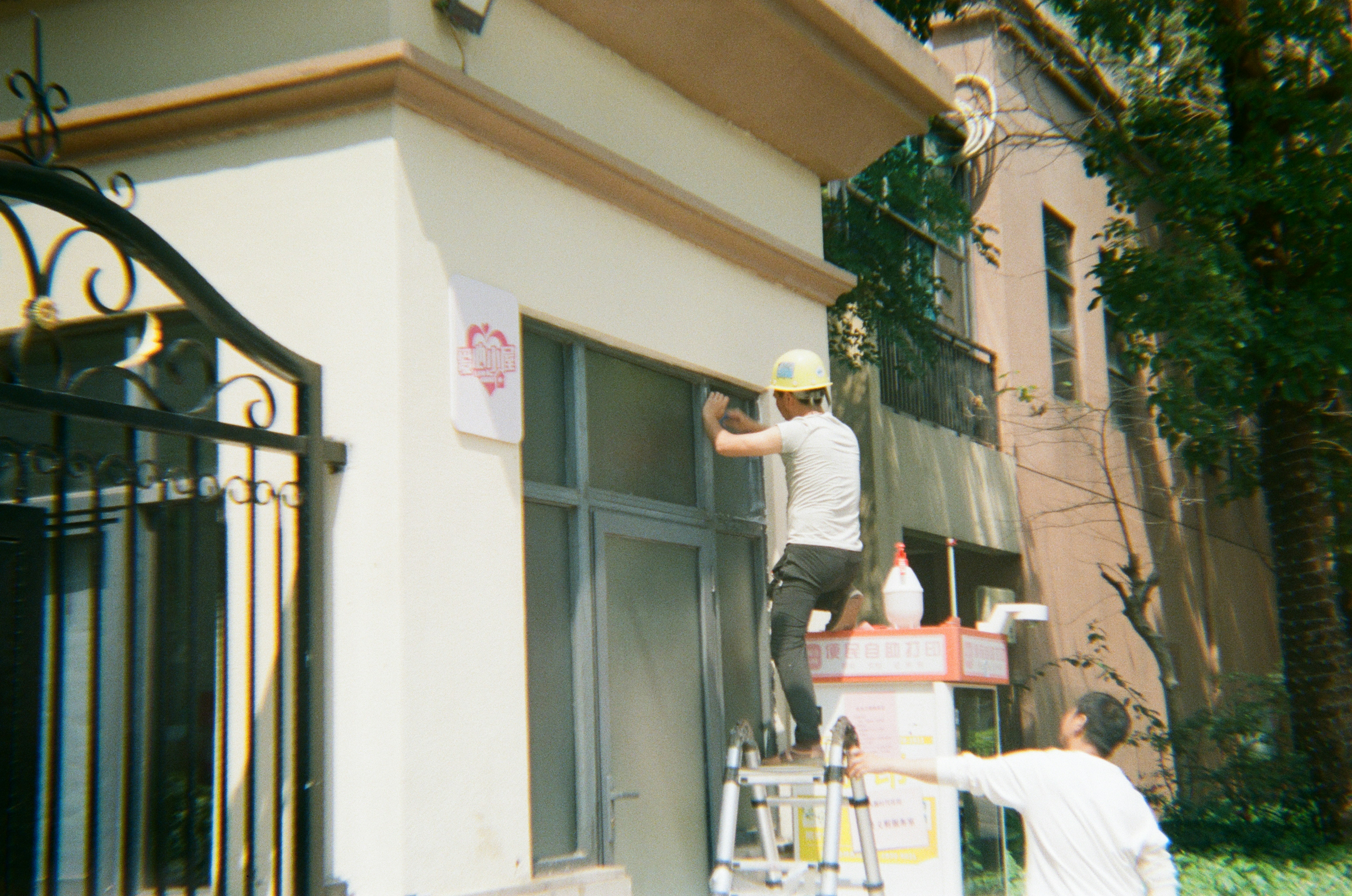 Dos hombres trabajando en la fachada de un edificio.