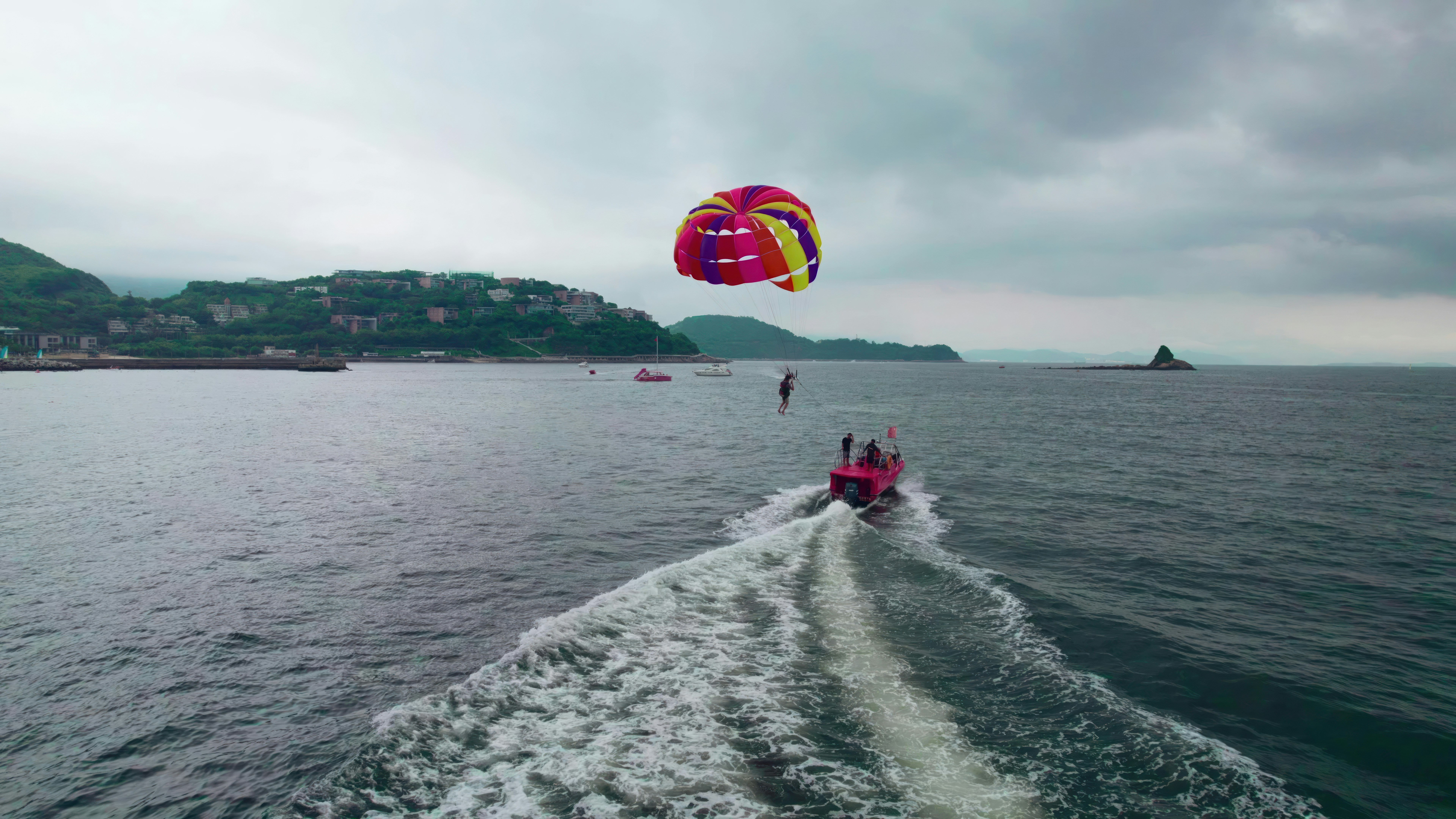 People parasailing behind a boat on the ocean