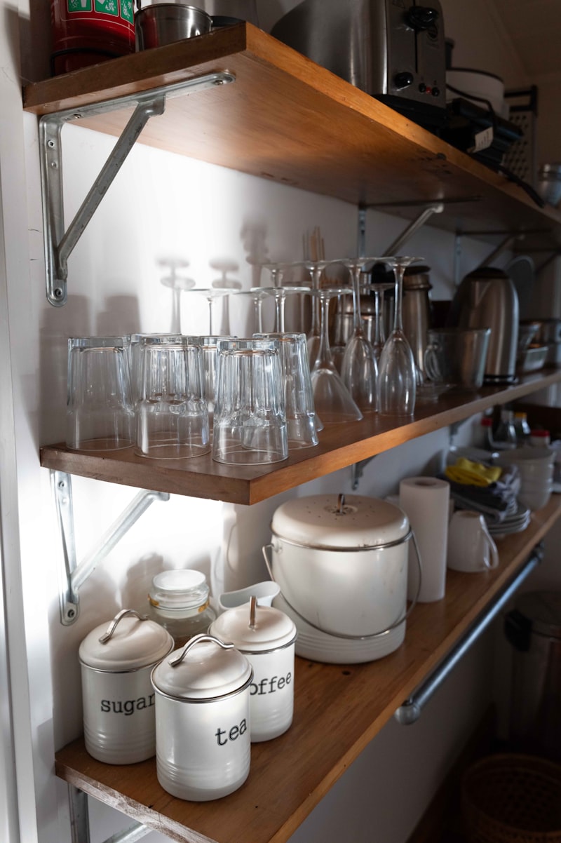 Kitchen shelves stocked with glasses and storage jars