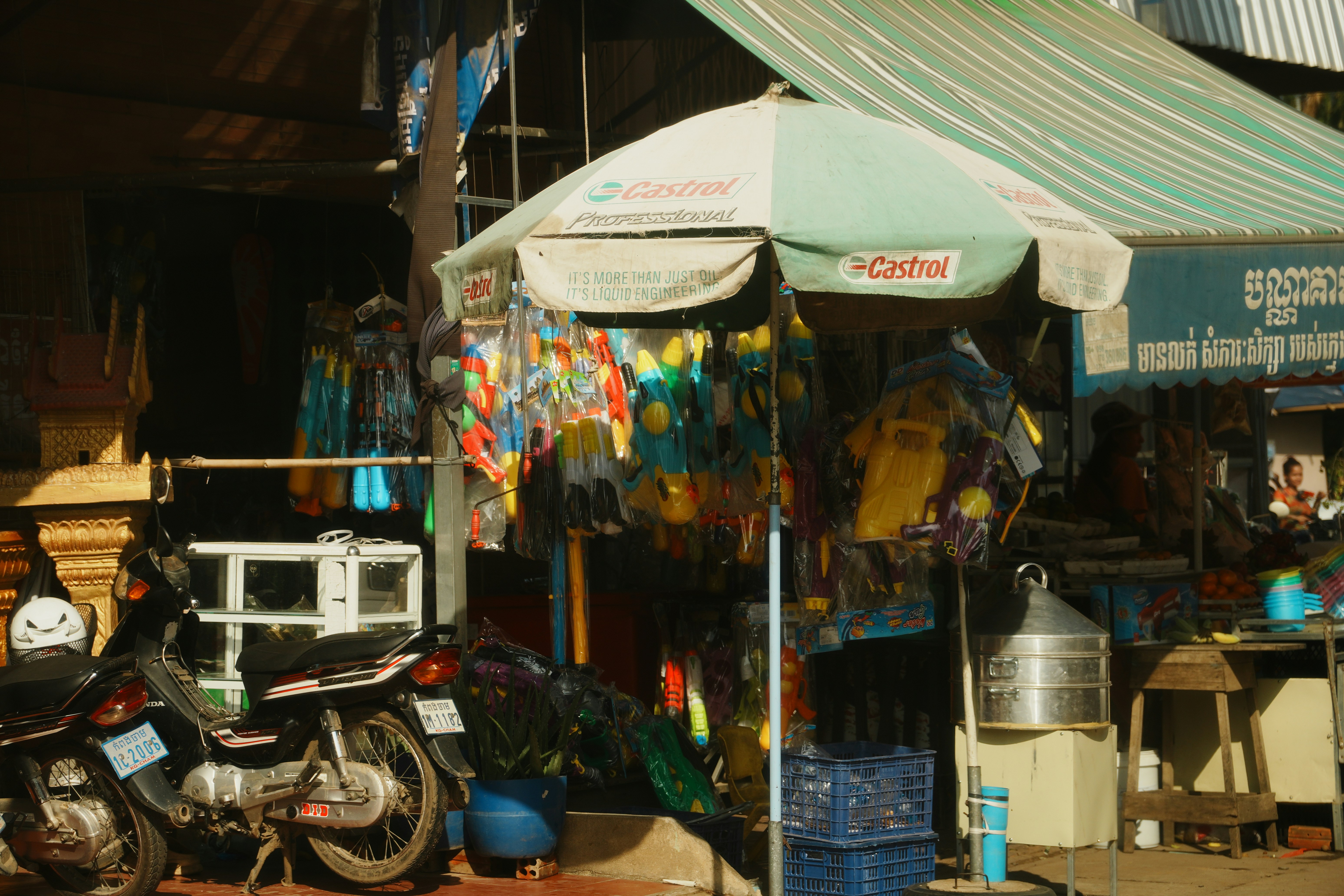 Street stall with colorful fabrics and motorcycles.