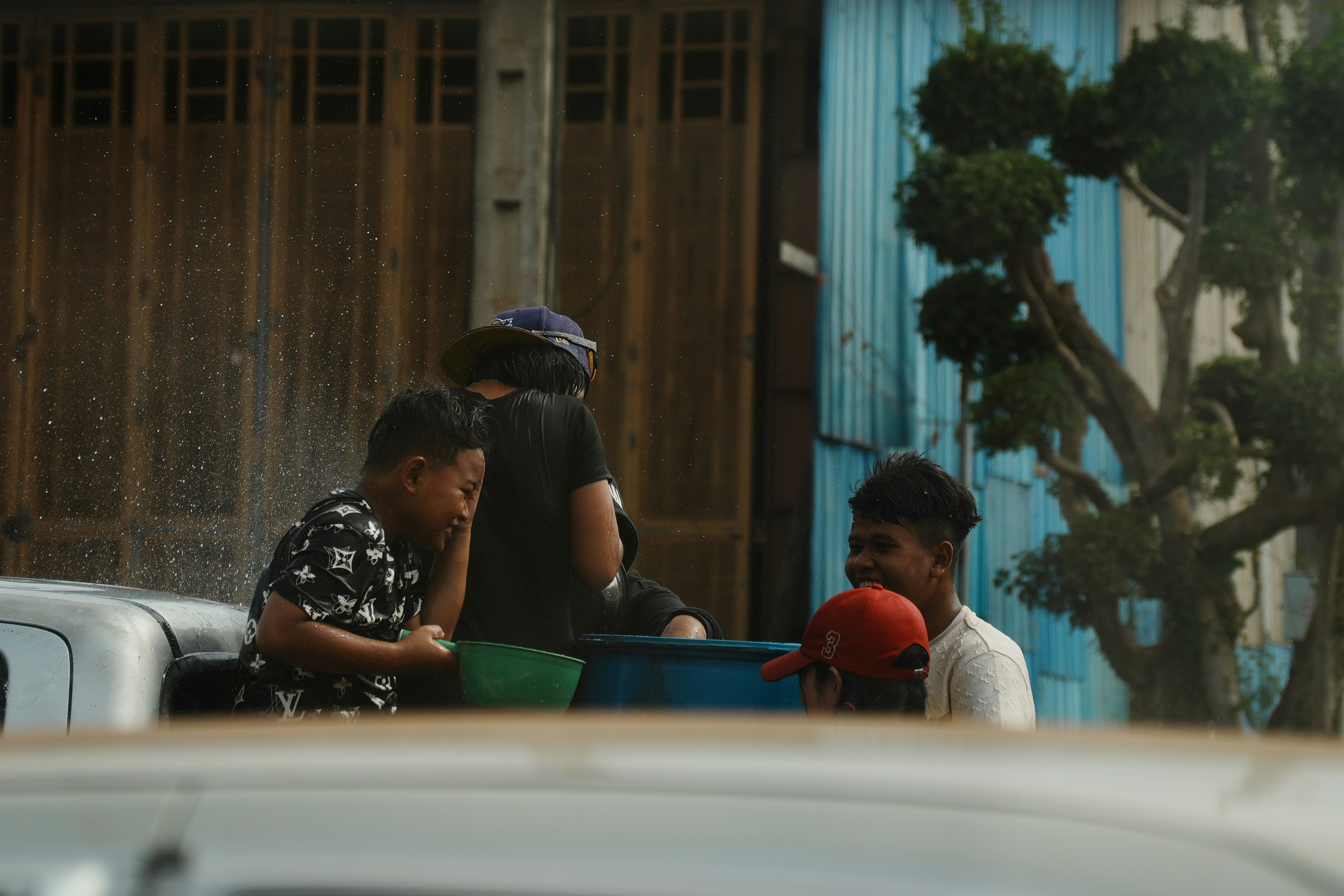 Children splashing water from a truck during a celebration