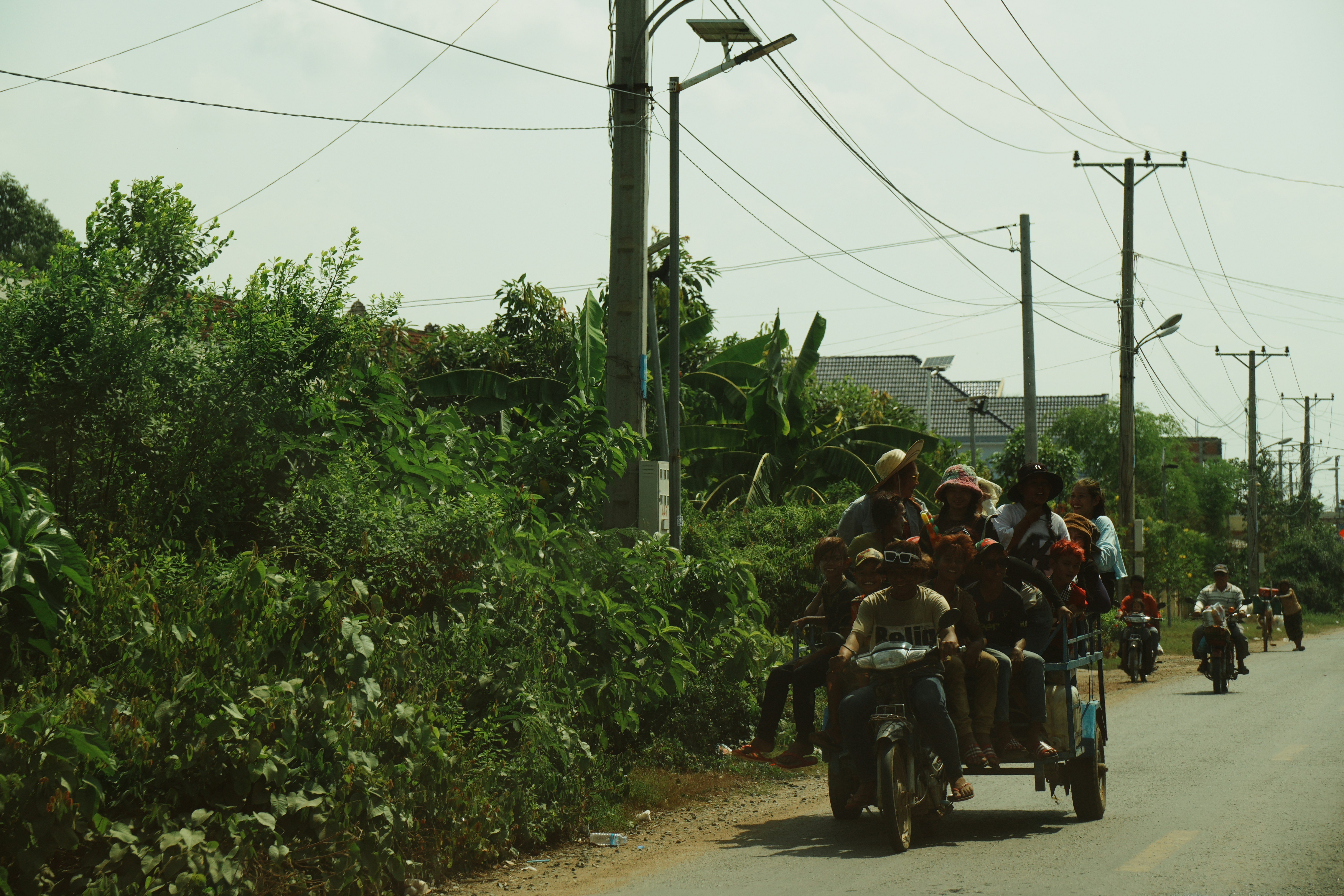 Motorcycle with sidecar carrying many people on road.