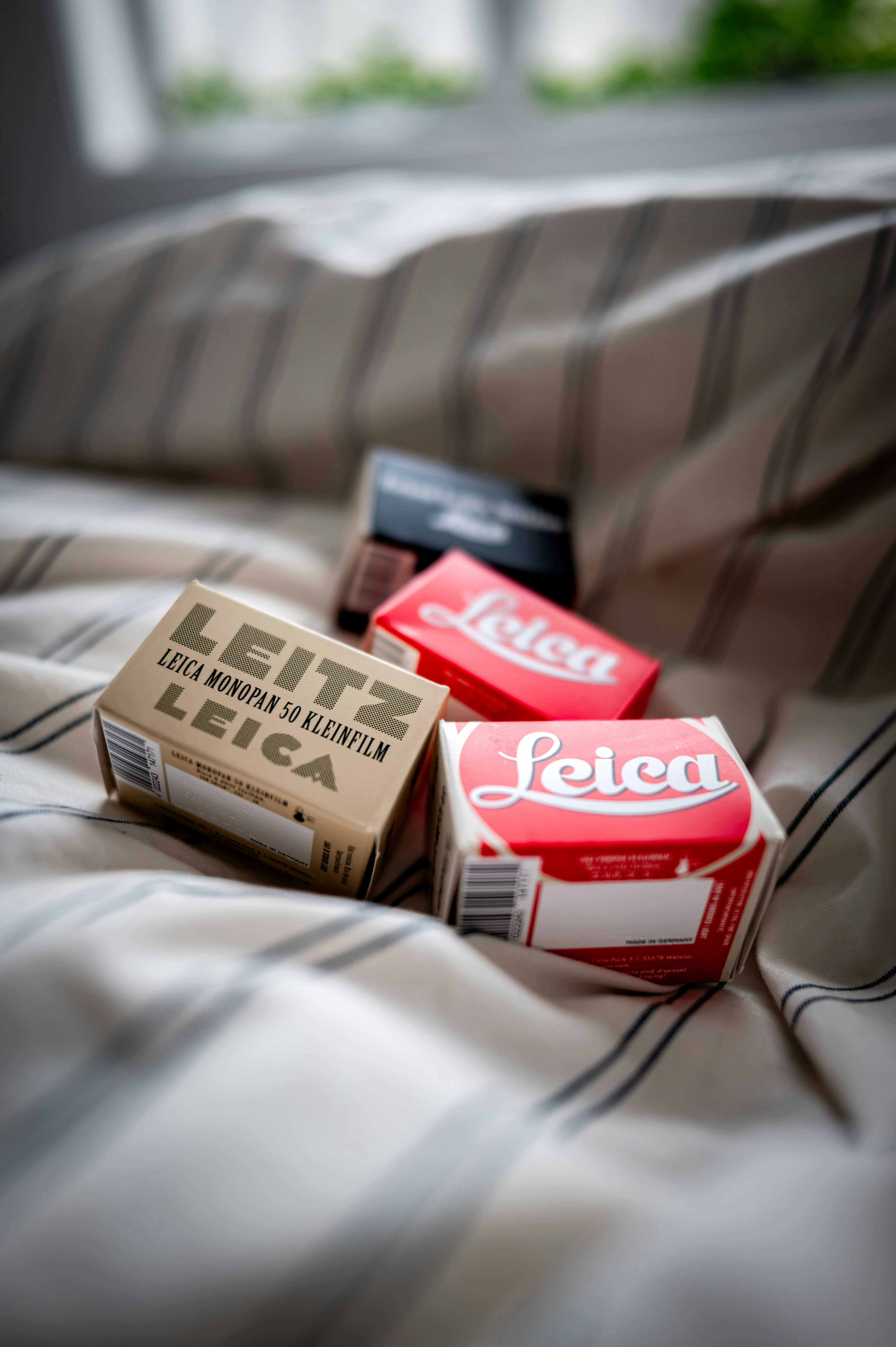 Leica film boxes resting on a striped blanket.