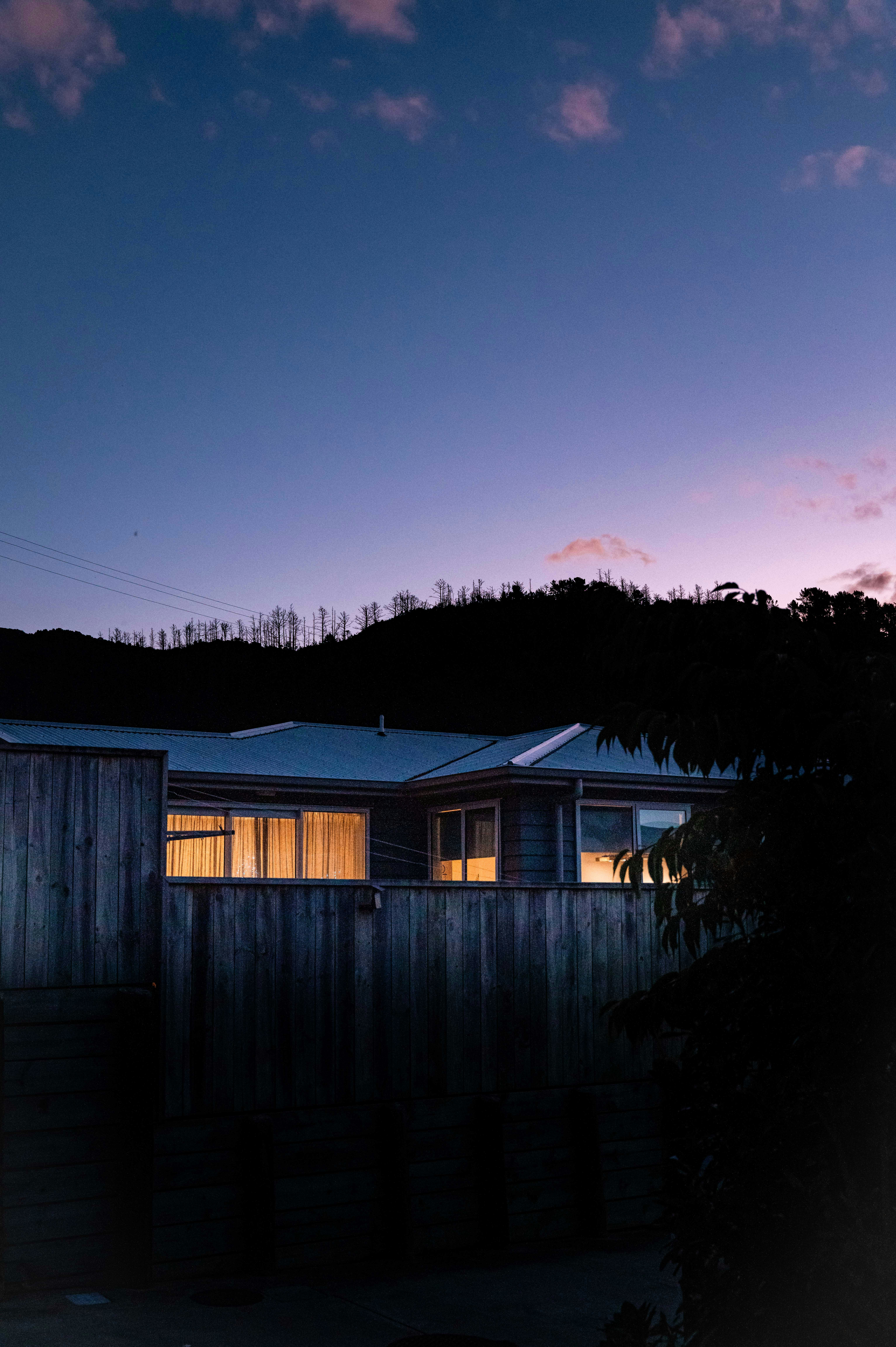 Residential exterior at dusk with warm interior lighting