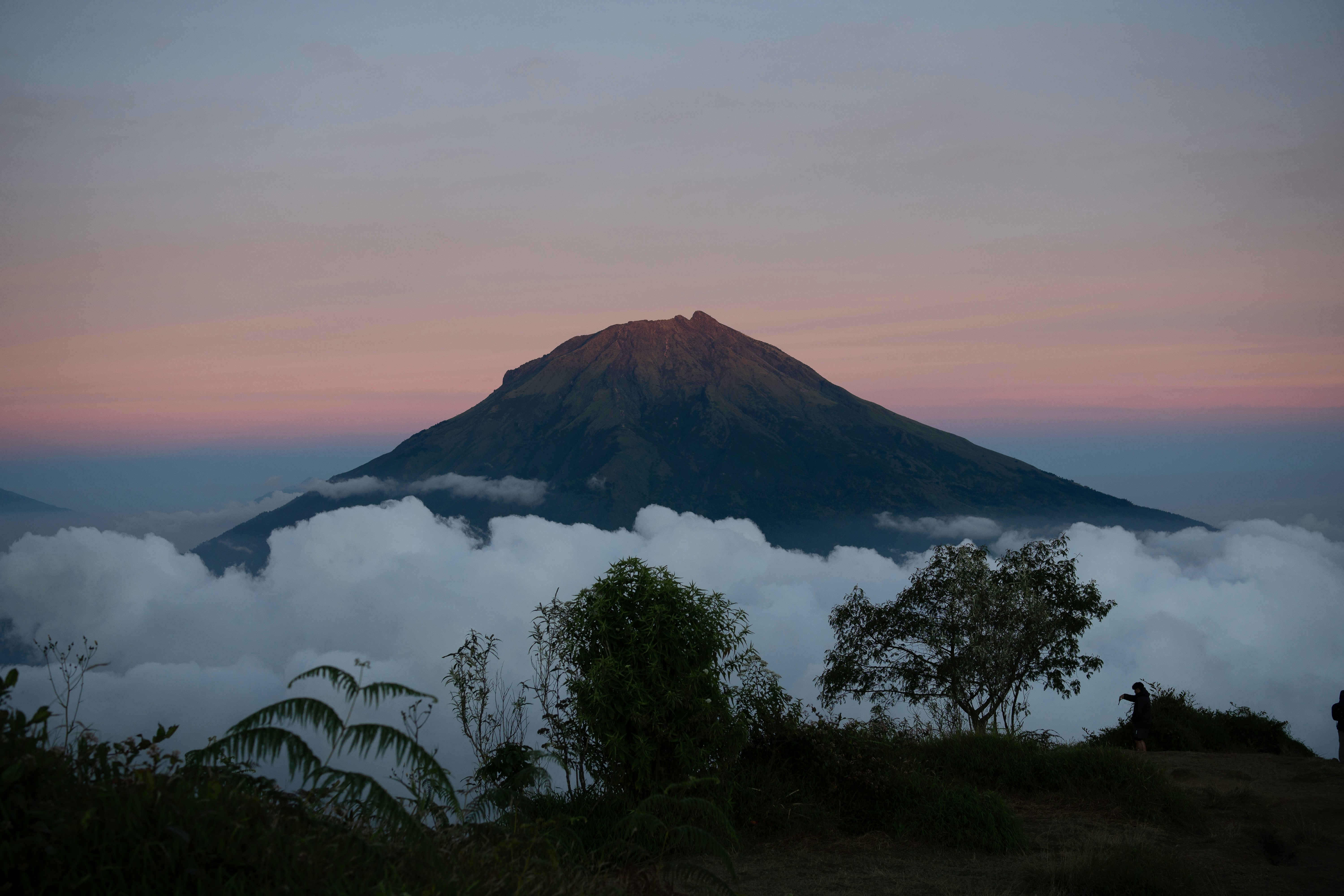 Pico da montanha emergindo das nuvens ao amanhecer.
