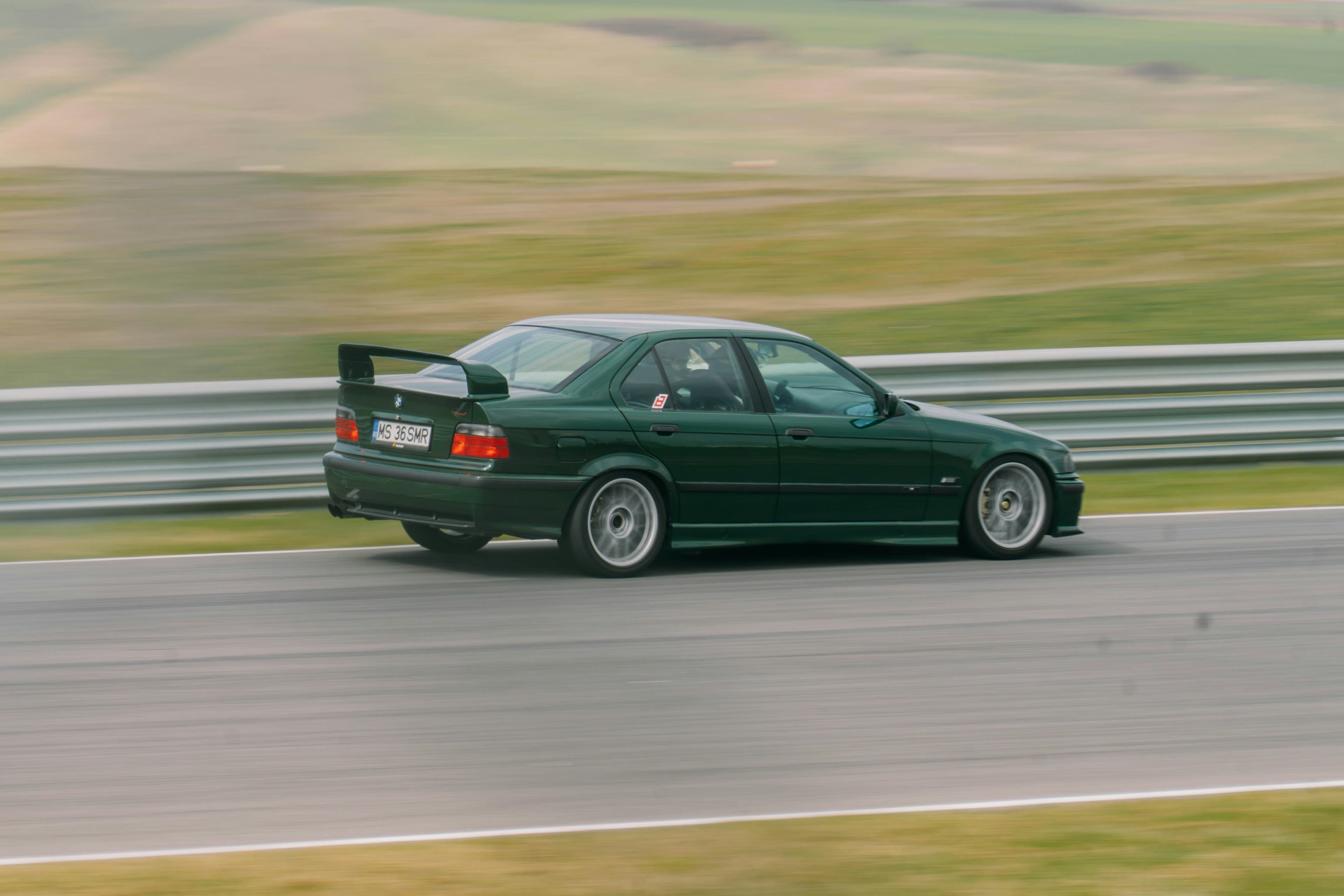 Una sportiva verde con uno spoiler su una pista da corsa