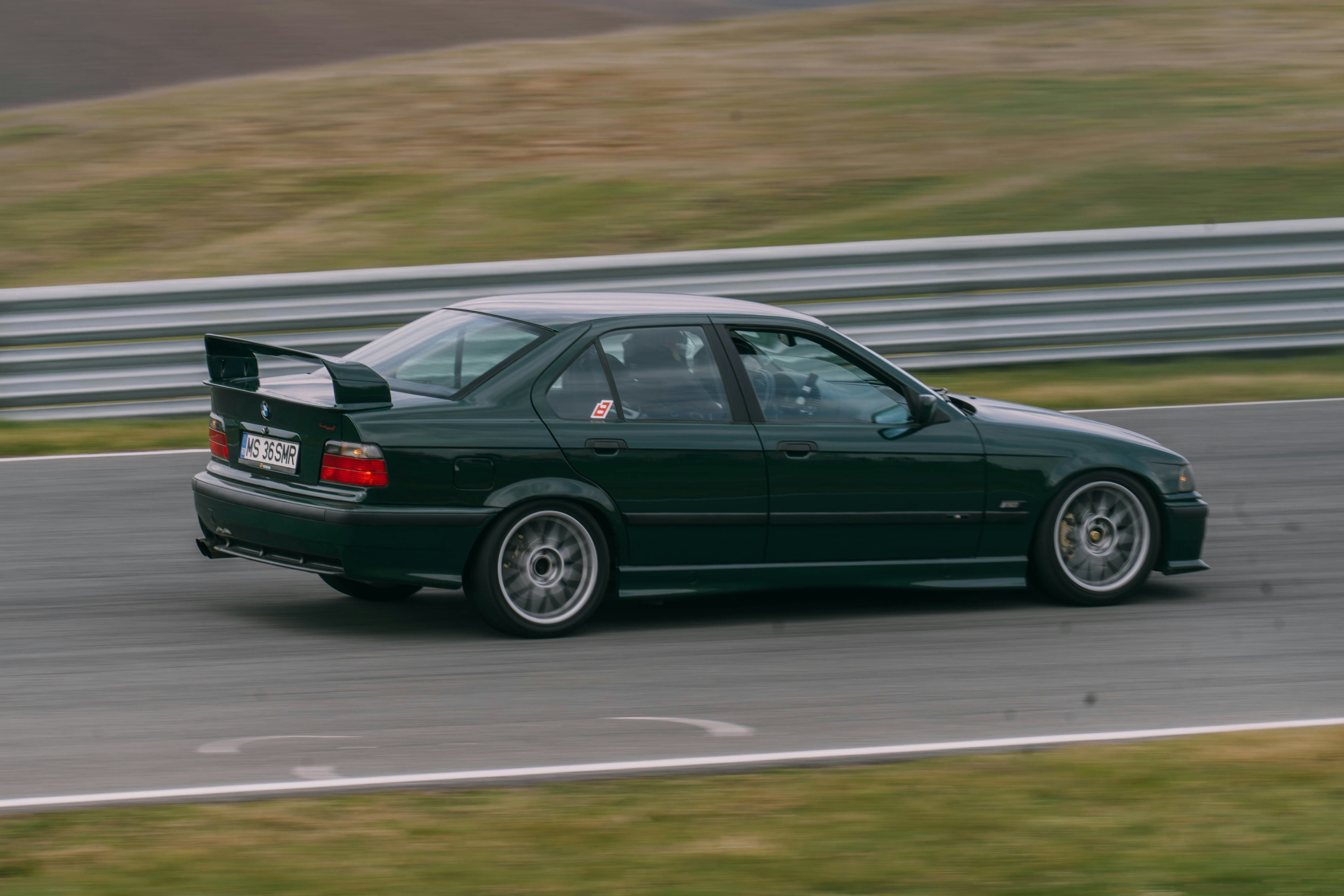 A dark green BMW m3 on a racetrack.