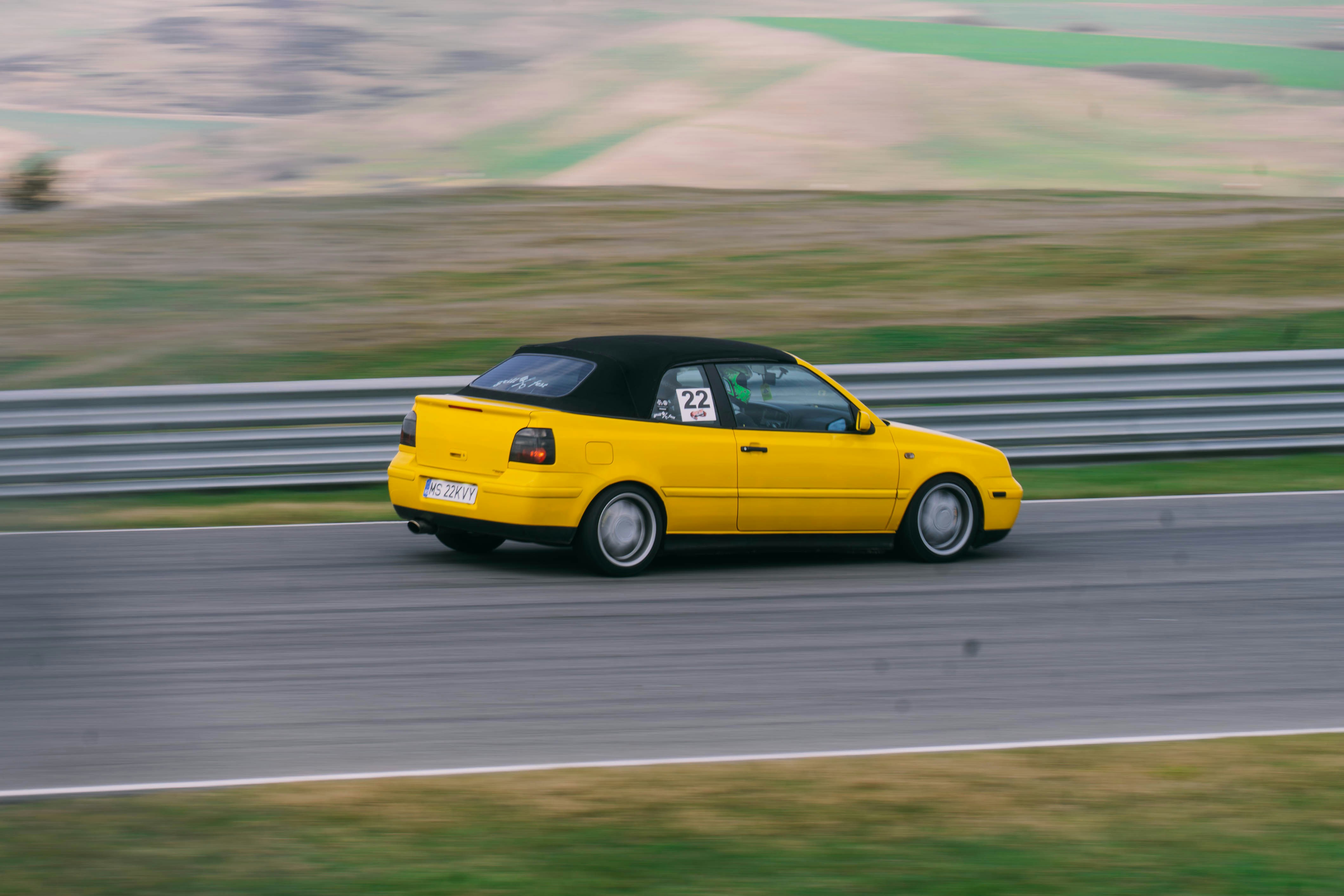 Decappottabile gialla che guida su una pista da corsa.