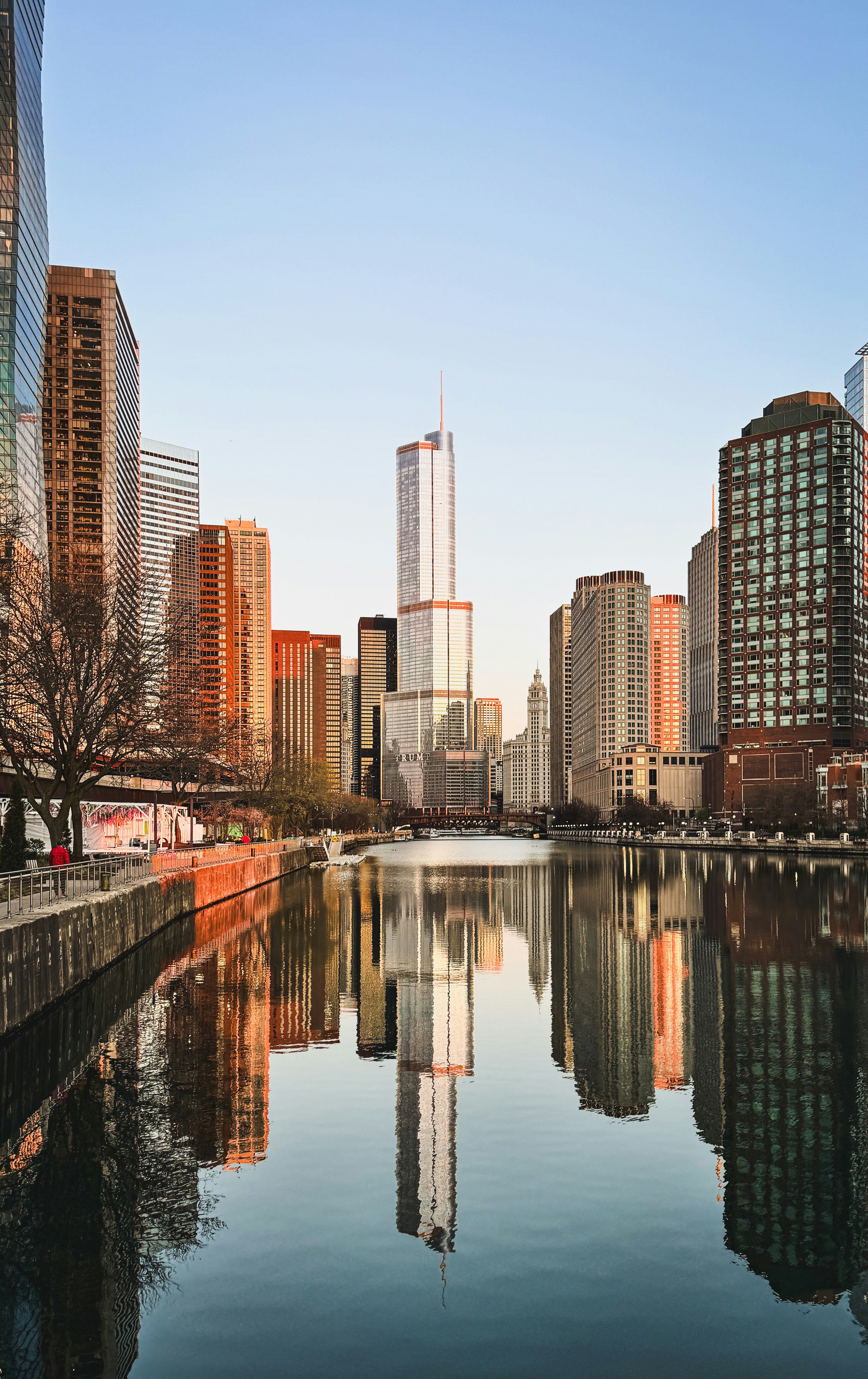 O horizonte da cidade com o rio refletindo prédios ao pôr do sol.