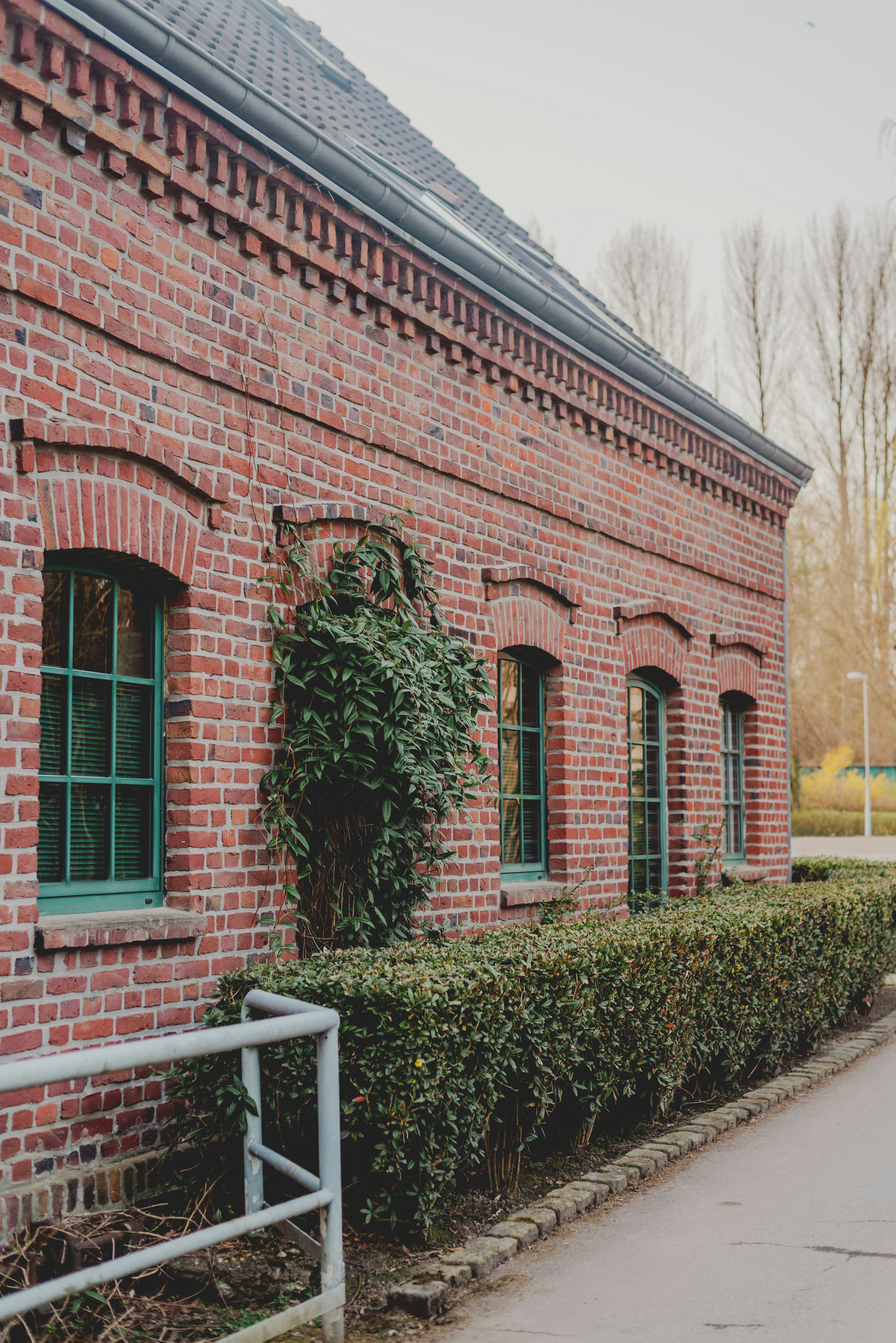 녹색 창문과 울타리가 있는 붉은 벽돌 건물