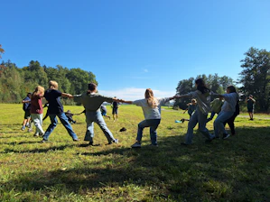 Children playing tug-of-war in a grassy field