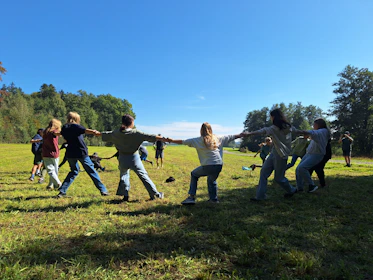 Children playing tug-of-war in a grassy field