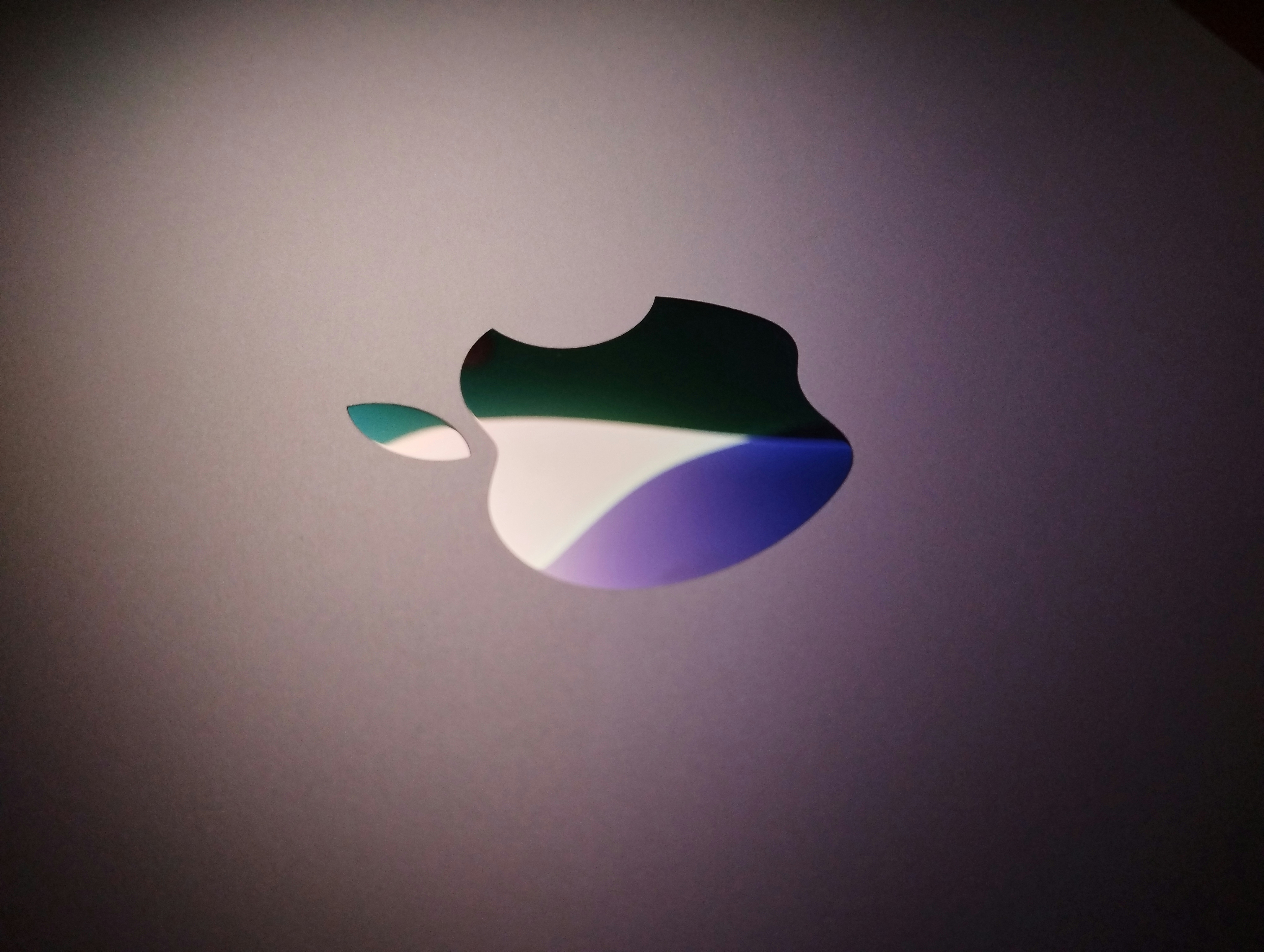 Close-up of an apple logo with colorful reflections