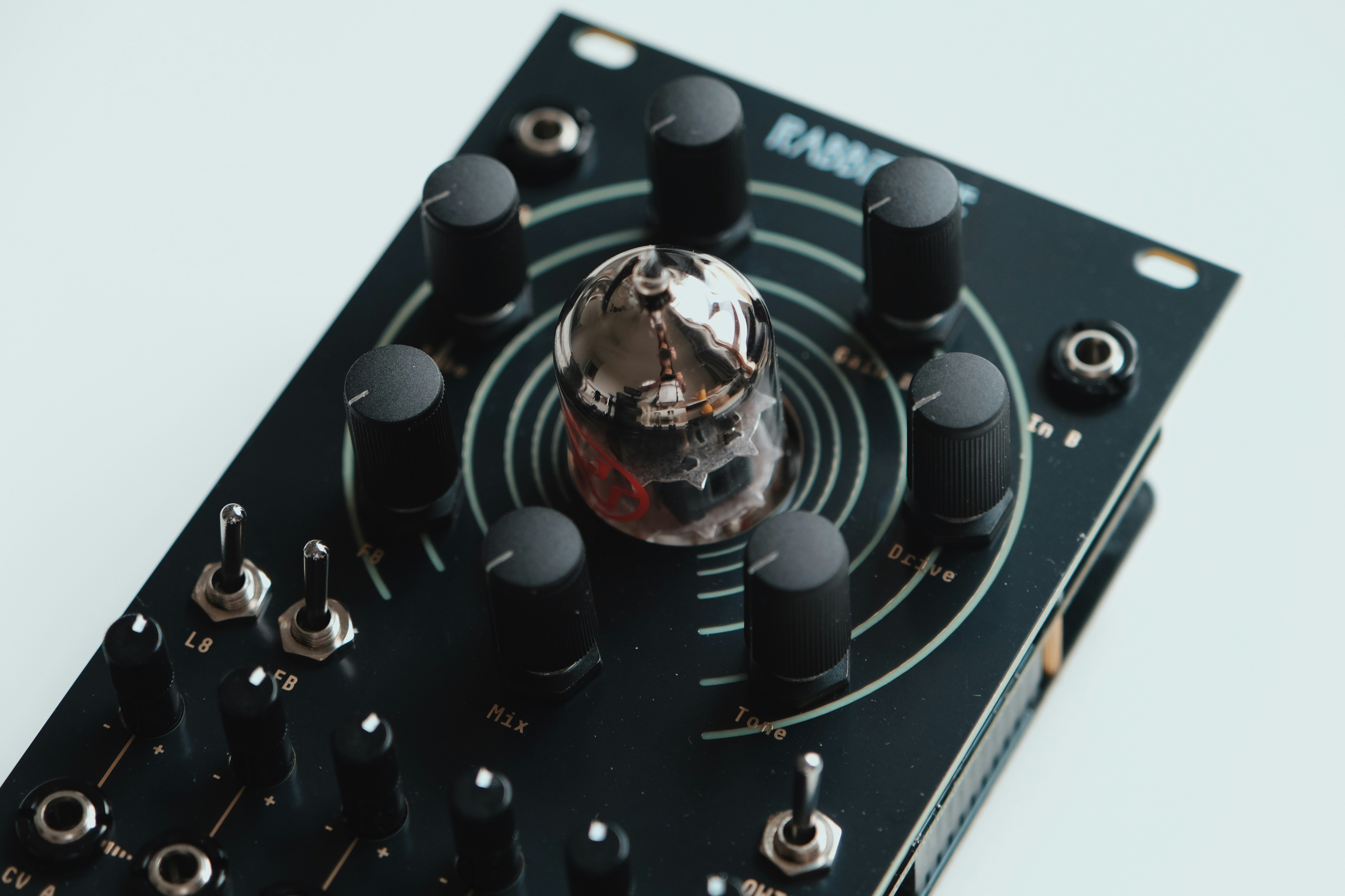 Close-up of a black electronic device with knobs and switches.