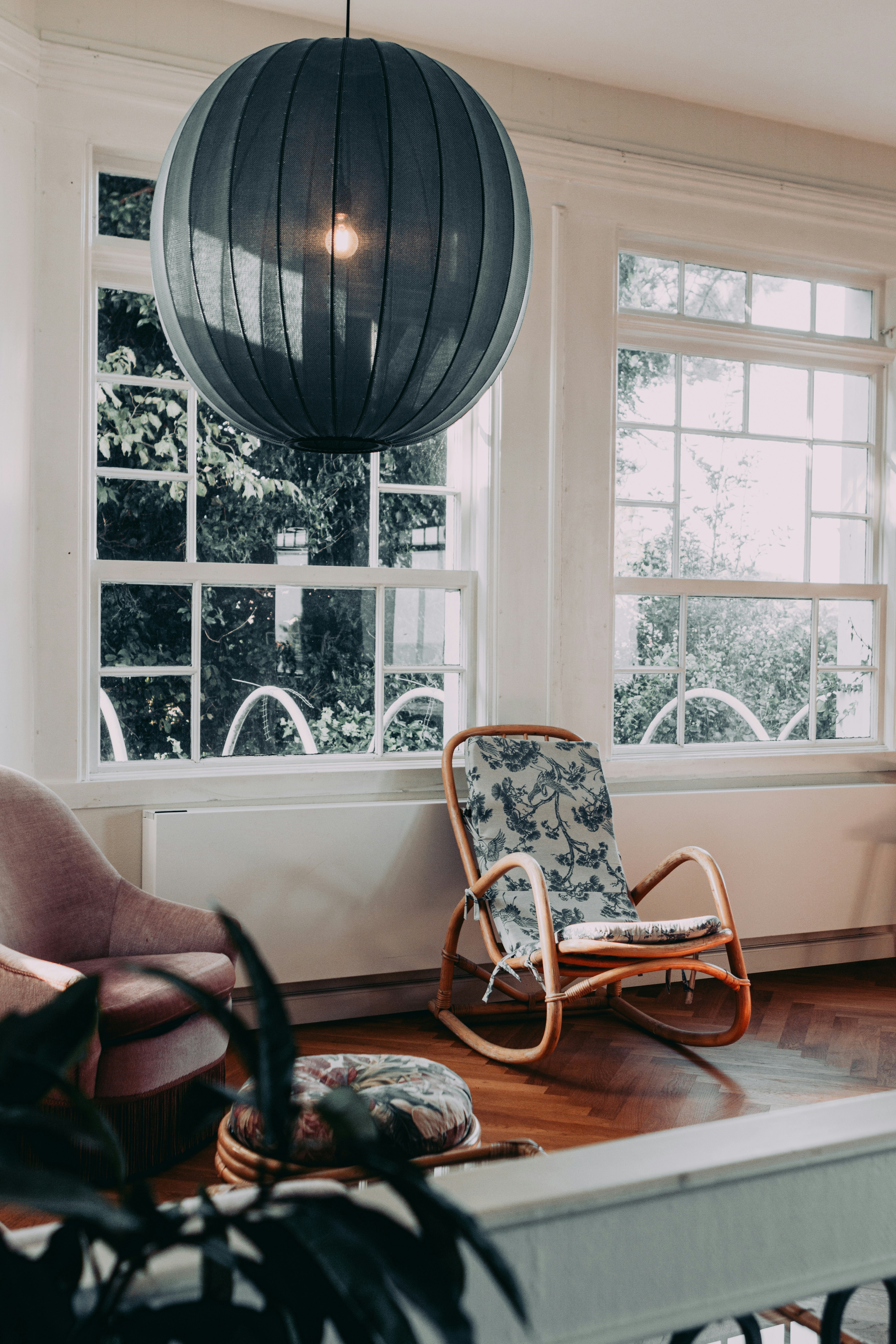 A cozy room with rocking chair and large windows.