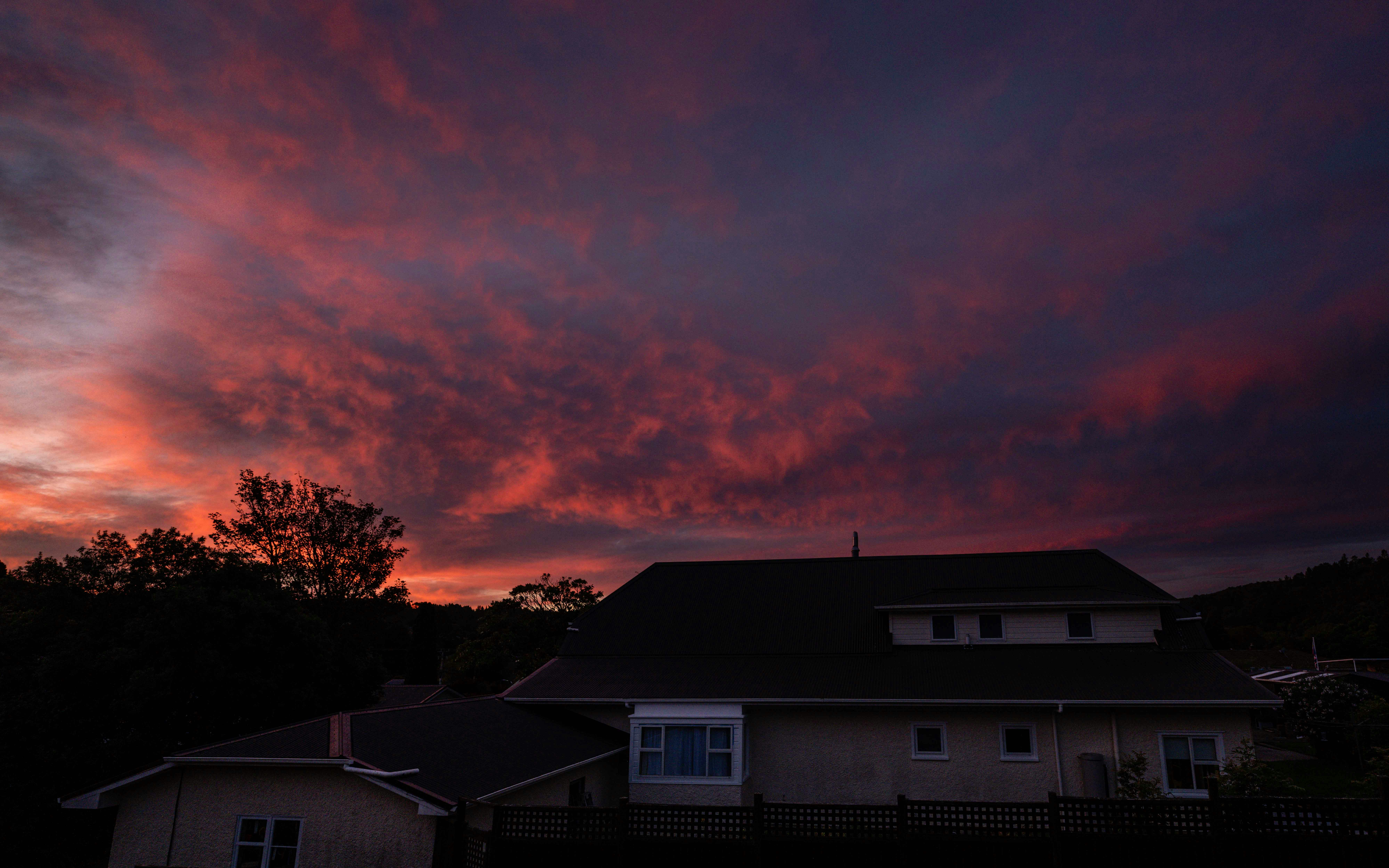 Dramatic sunset sky over houses and trees
