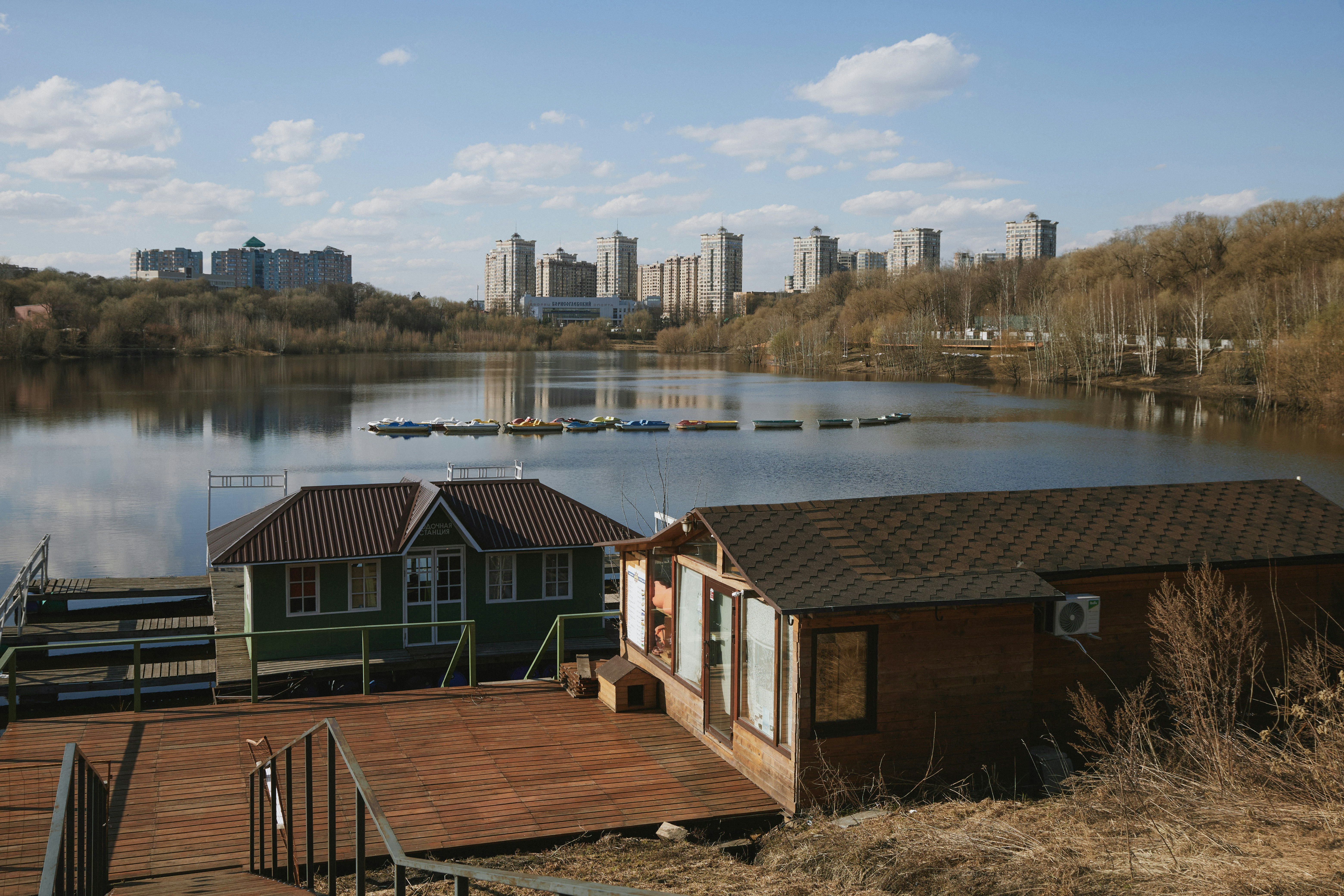 Boathouses on a lake with city skyline in background