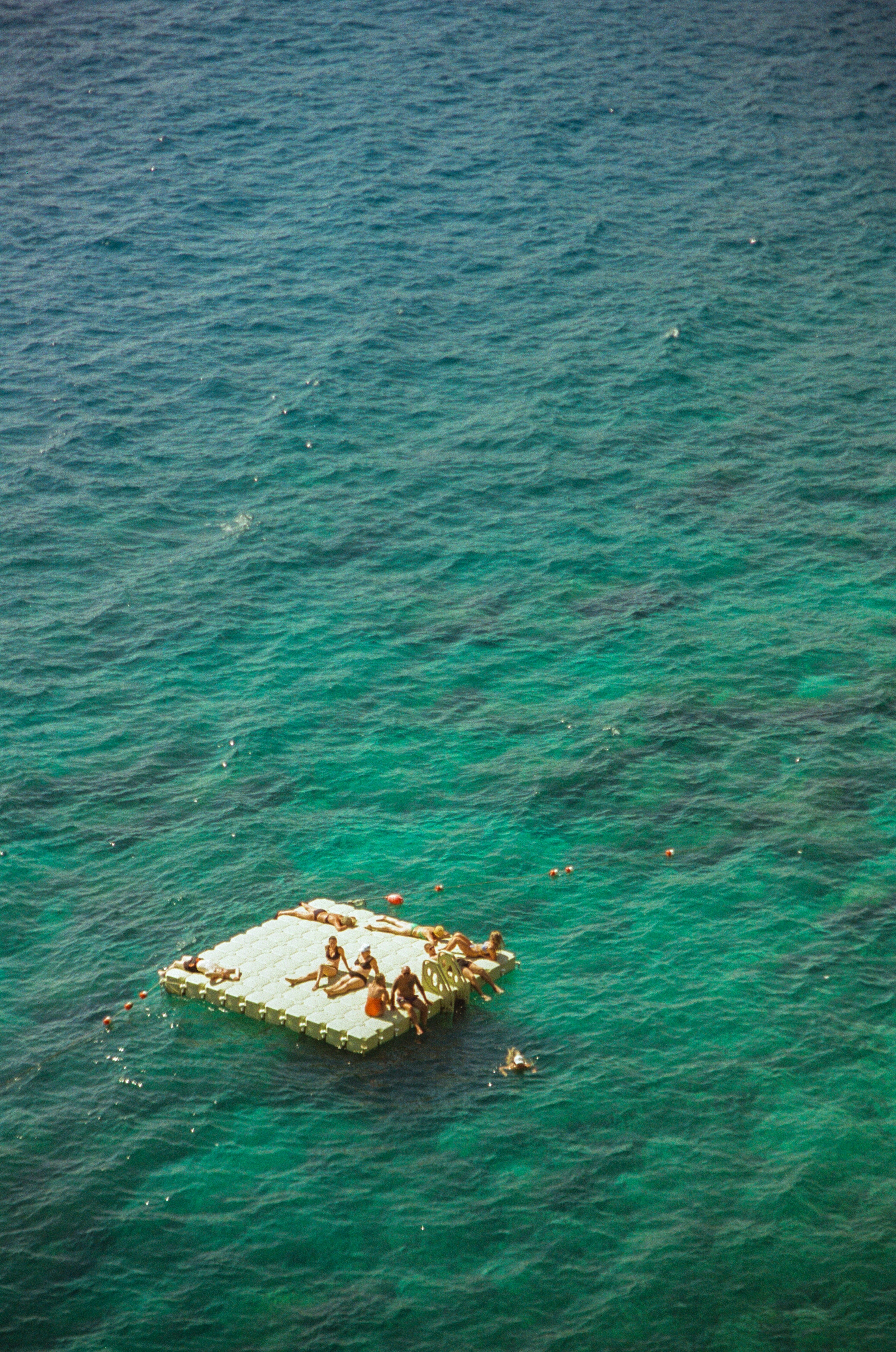 People relaxing on a floating raft in clear blue ocean. photo – Free ...