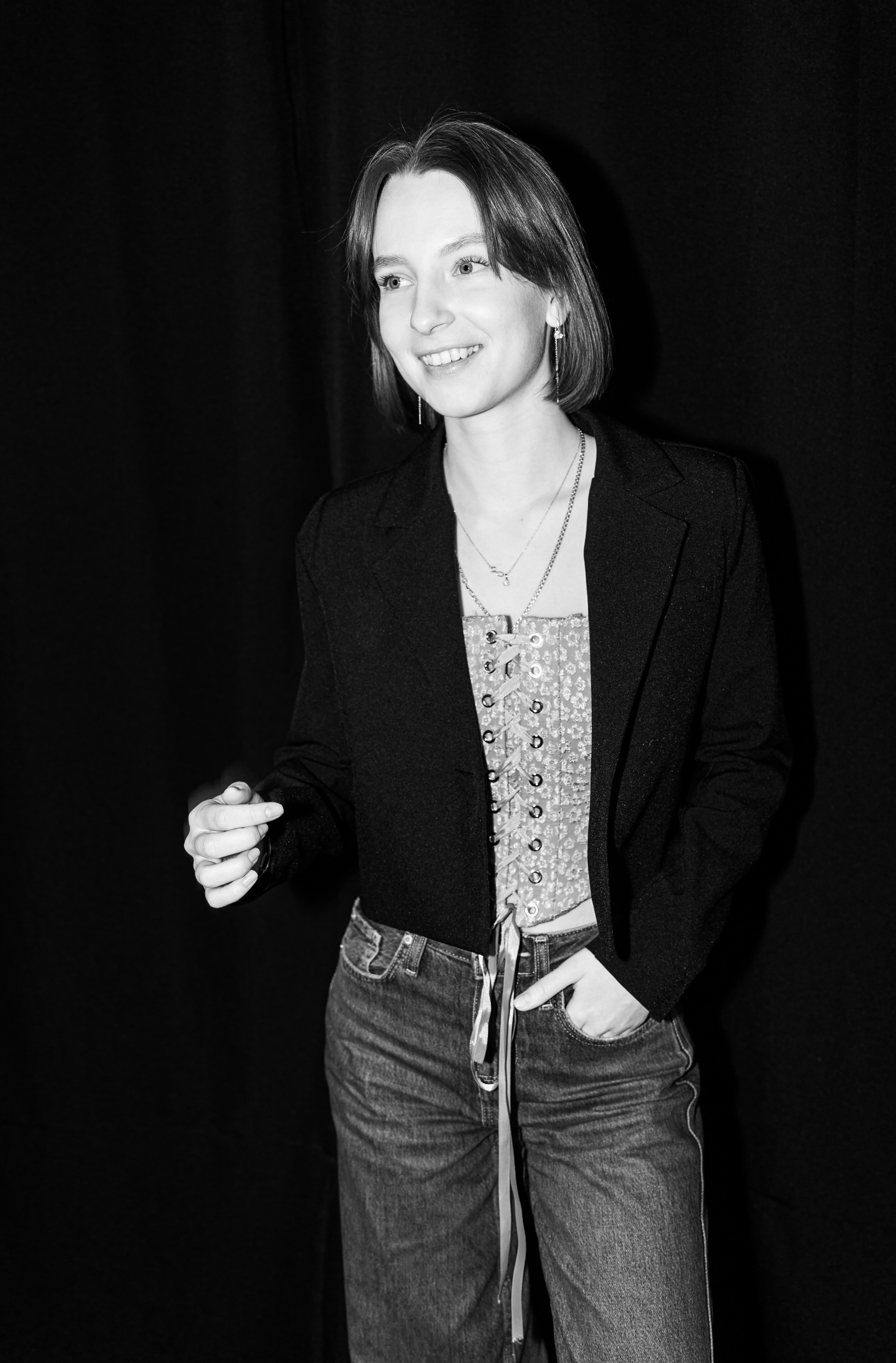 Jeune femme en veste et jean sourit